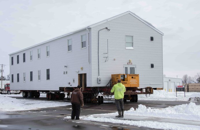 Contractors with JMJ Construction of New Lisbon, Wis., along with support from Heritage Movers of Blue River, Wis., move a World War II-era building in the 1600 block on the cantonment area Feb. 24, 2023, at Fort McCoy, Wis. The contractors are relocating and repairing four barracks buildings that are currently located in the 1600 block to alternate locations in the 1700 and 1800 blocks, according to the Fort McCoy Directorate of Public Works. The plan is to relocate the buildings to the new locations before the ground thaws, then lift them onto the new foundations and complete the remaining work by summer 2023. This was the first time in Fort McCoy's history a barracks building was moved like this. (U.S. Army Photo by Greg Mason)