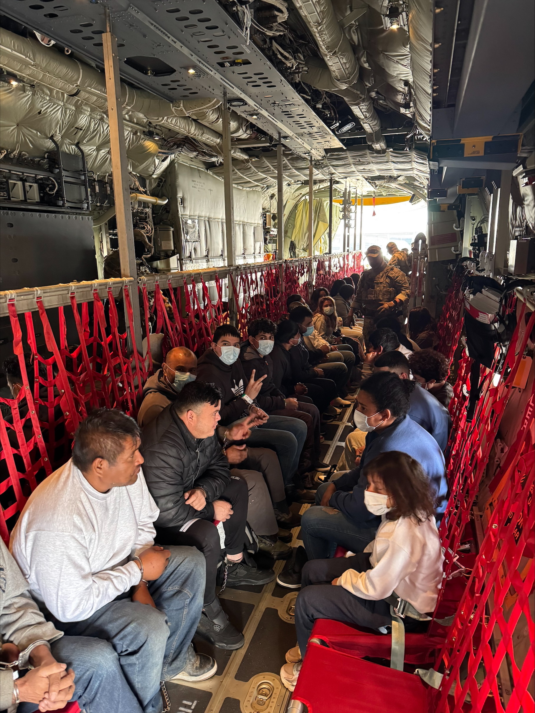 People sit inside a Coast Guard plane.