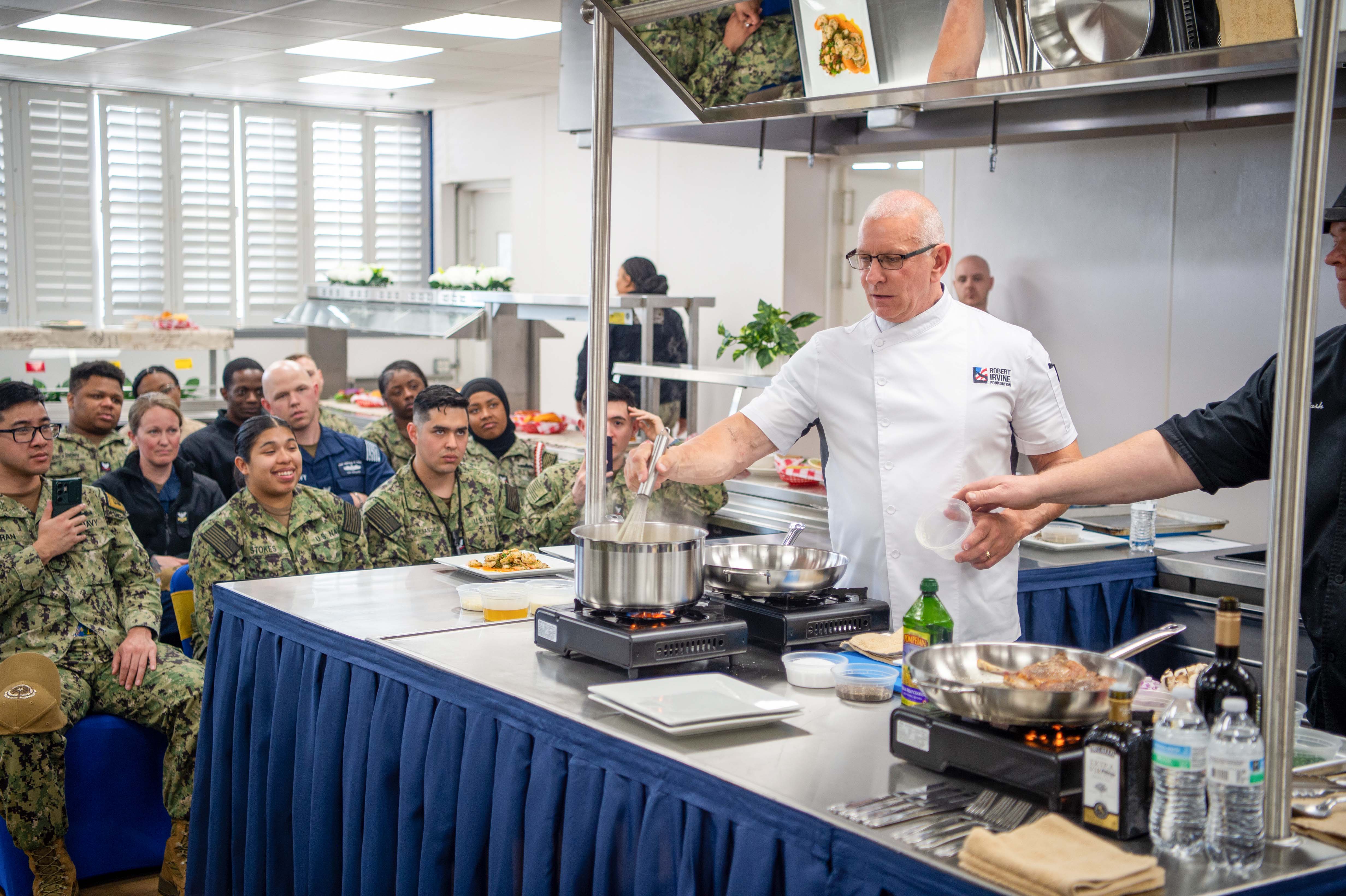 Chef Robert Irvine instructing sailors on healthy cooking.