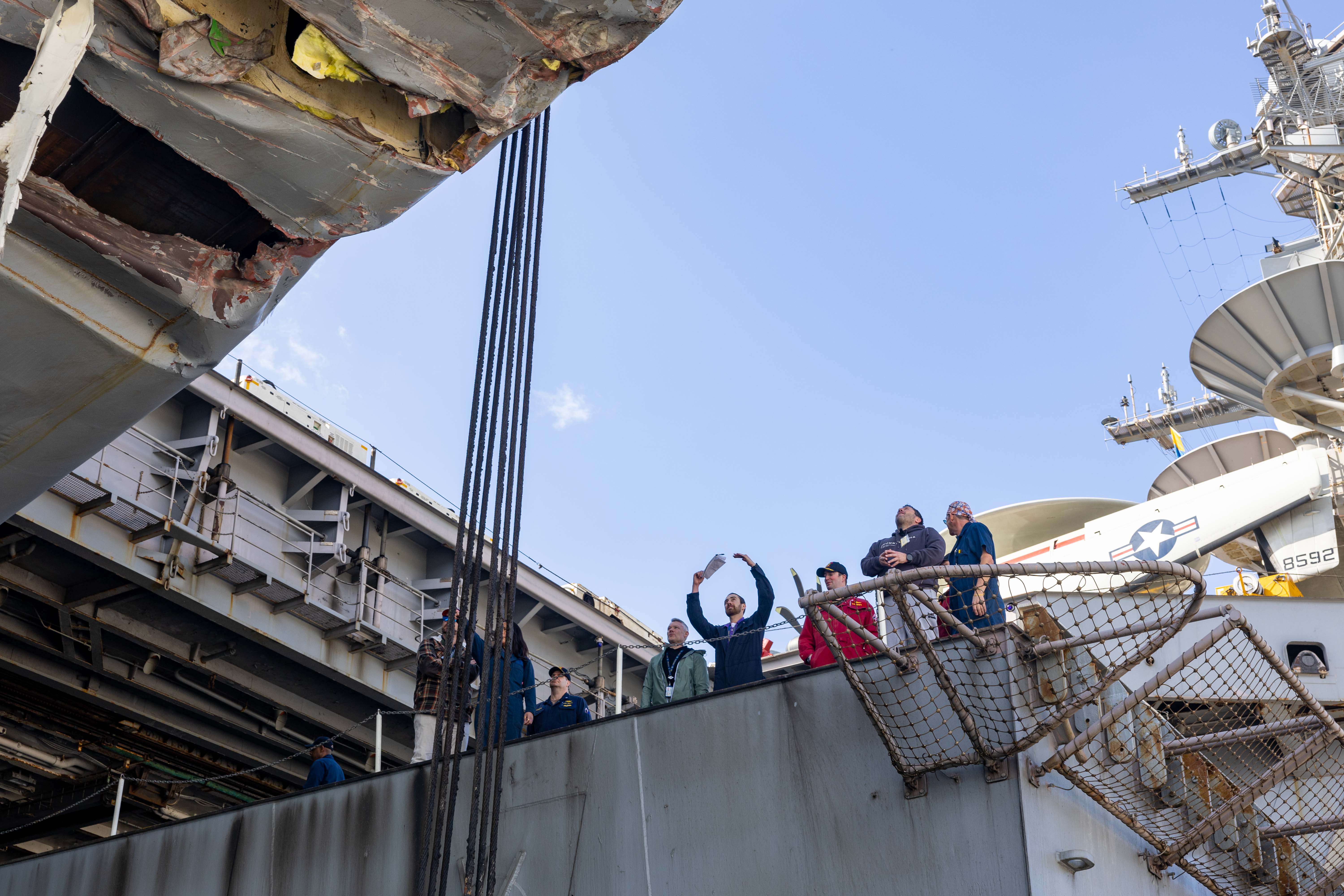 250216-N-DL824-2012 SOUDA BAY, Greece (Feb. 16, 2025) Engineering department officers, assigned to the Nimitz-class aircraft carrier USS Harry S. Truman (CVN 75) and Forward Deployed Regional Maintenance Center inspectors assess the exterior damage of the ship, Feb. 16, while completing an emergent repair availability at U.S. Naval Support Activity (NSA) Souda Bay. USS Harry S. Truman, the flagship of the Harry S. Truman Carrier Strike Group (HSTCSG), is on a scheduled deployment in the U.S. 6th Fleet area of operations supporting U.S. Naval Forces Europe-Africa to defend U.S., Allied and partner interests. (U.S. Navy photo by Mass Communication Specialist Seaman Michael Gomez)