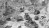 A black and white photo showing several U.S. Army tanks moving through the rubble of a bombed out German city.