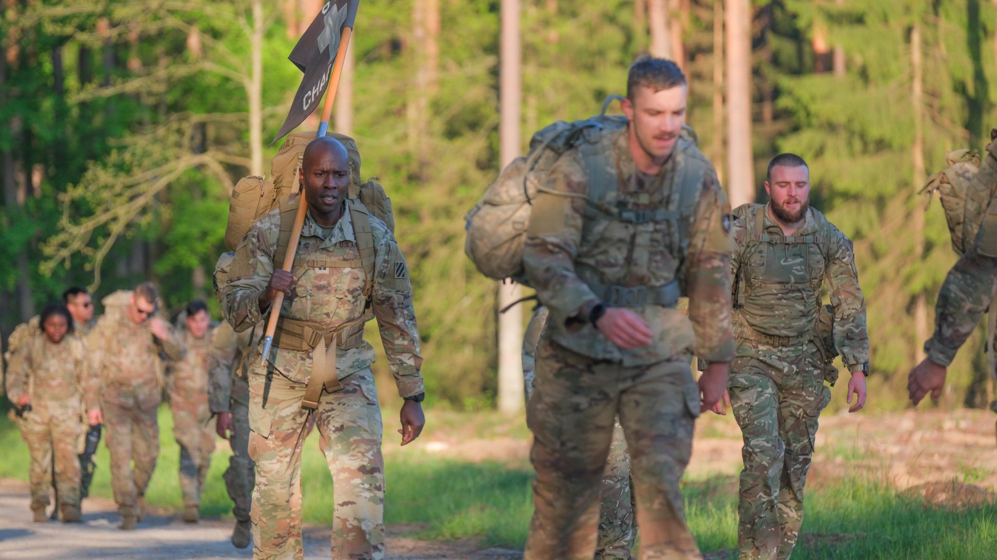 U.S. Army Capt. Walton Brown (left), chaplain with 1st Battalion, 64th Armored Regiment, 1st Armored Brigade Combat Team, 3rd Infantry Division, in support of Task Force Iron, marches alongside NATO Multinational Battle Group Poland soldiers during a Memorial Day ruck march at Bemowo Piskie Training Area, Poland, May 26, 2025. U.S. soldiers joined service members from Romania, the United Kingdom, and Croatia to honor those who made the ultimate sacrifice while serving in their countries’ armed forces. Task Force Iron’s mission is to engage in multinational training and exercises across the continent to increase lethality while strengthening partnerships with NATO allies and regional security partners. The task force provides combat-credible forces to V Corps, America’s only forward-deployed corps in Europe.