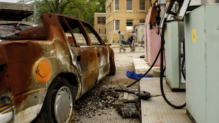 Soldiers carry a simulated casualty dummy during an EMP exercise.
