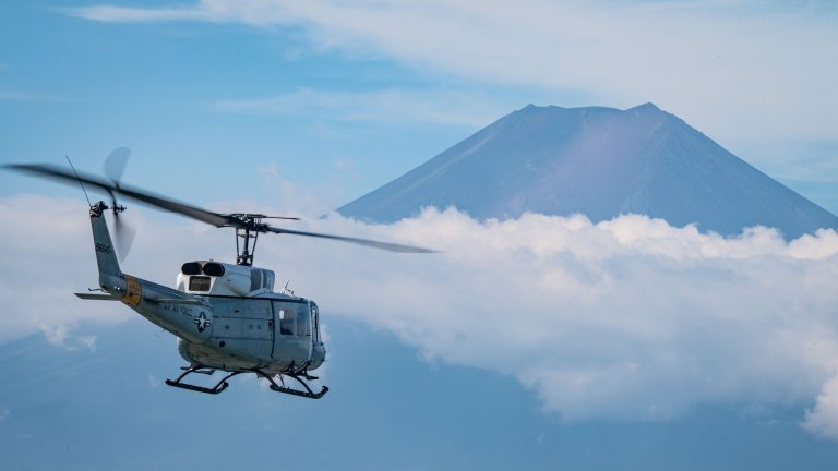 A UH-1N Huey flies over Tokyo.