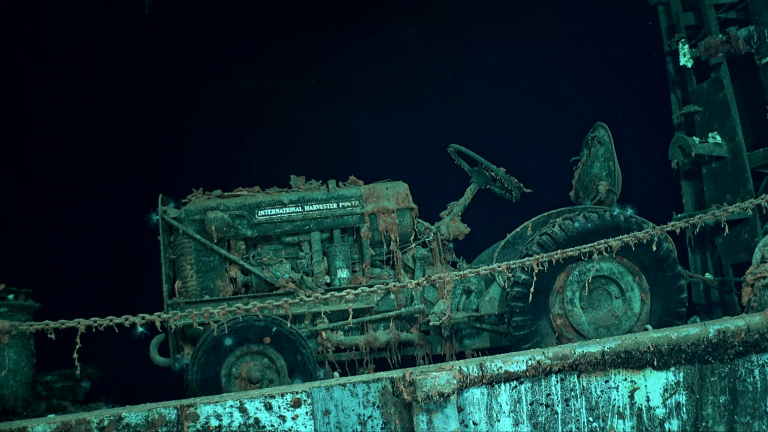 An international harvester tractor strapped to the wreck of the World War II USS Hornet.