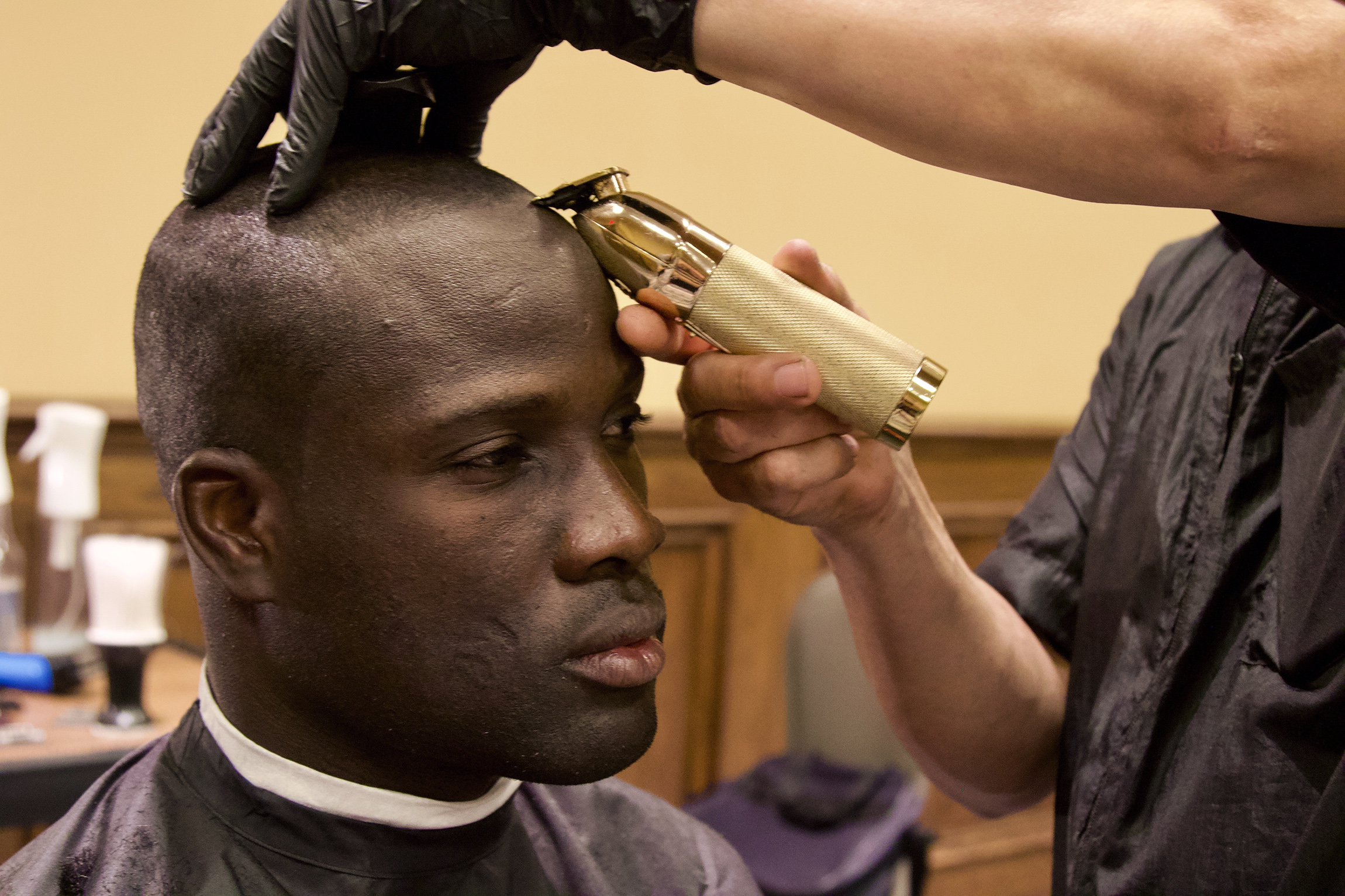 Florida National Guard Pfc. Ronald Thomas, with the 53rd Brigade Support Battalion, is able to keep his hair in Army regulations as a West Palm Beach barber tends to Soldiers supporting Palm Beach County, April 5, 2020. The makeshift ‘barber shop’ was setup in a hotel conference room where the barber wore a mask and gloves as a safety precaution.