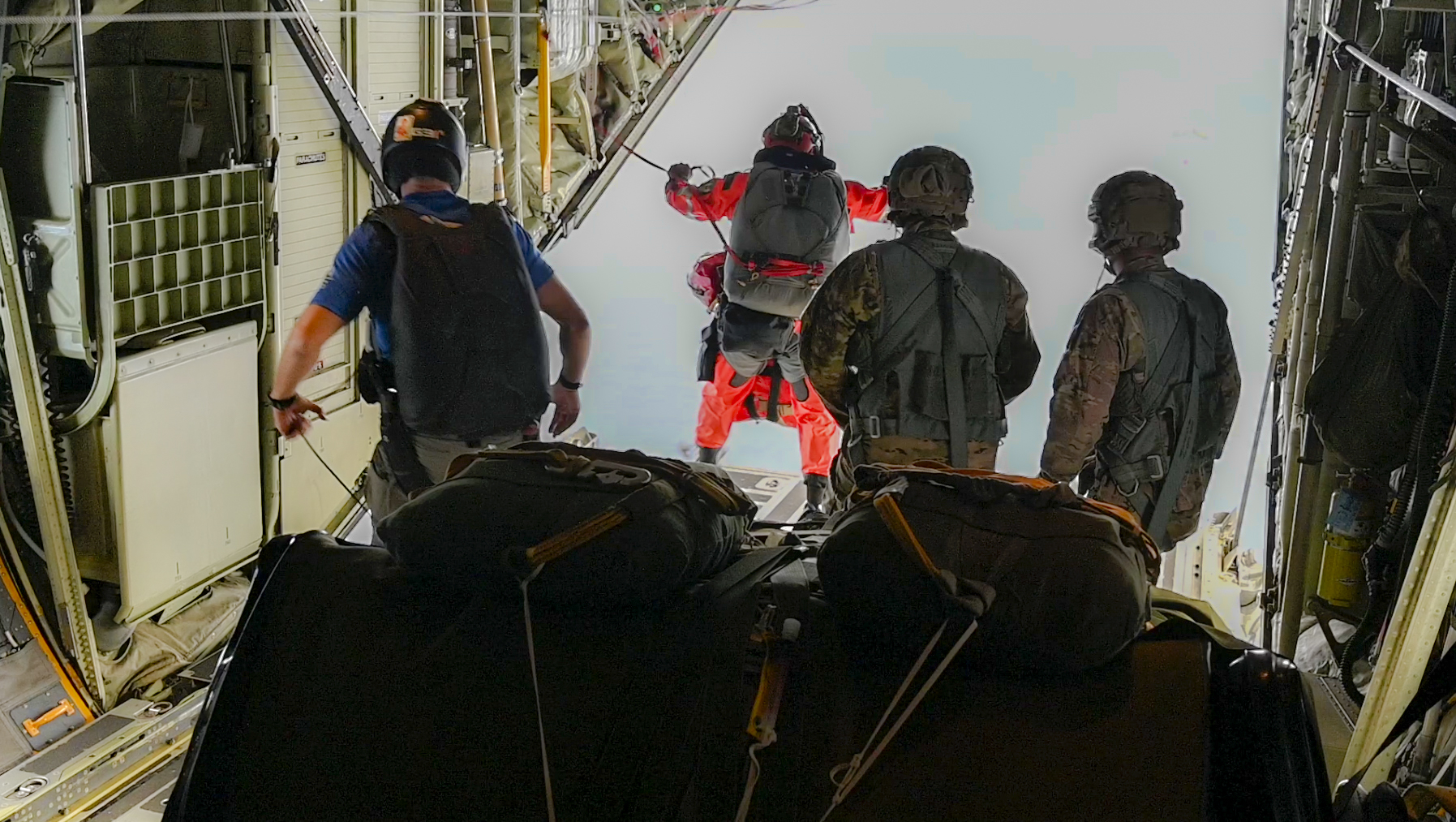 Guardian Angel team members from the 129th Rescue Wing, California Air National Guard, prepare to jump from an HC-130J Combat King II during a long-range maritime rescue mission approximately 885 nautical miles off the California coast. The team parachuted with medical equipment to reach the Panamanian-flagged cargo vessel Grand Vega and stabilize a Filipino mariner suffering stroke-like symptoms. (U.S. Air Force photo by Master Sgt. Joseph Prouse)