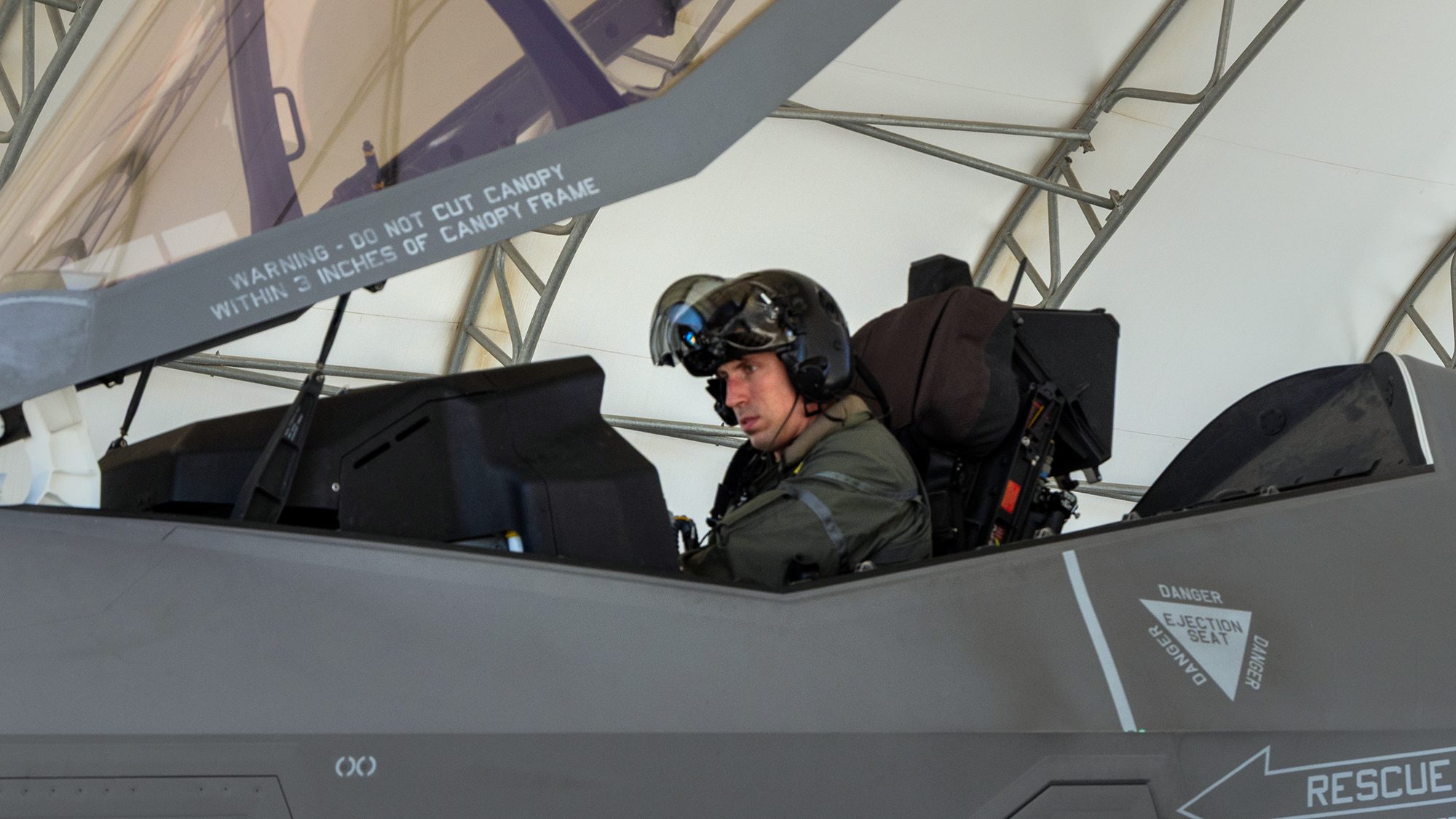Ross Elder sits inside the cockpit of a fighter plane.