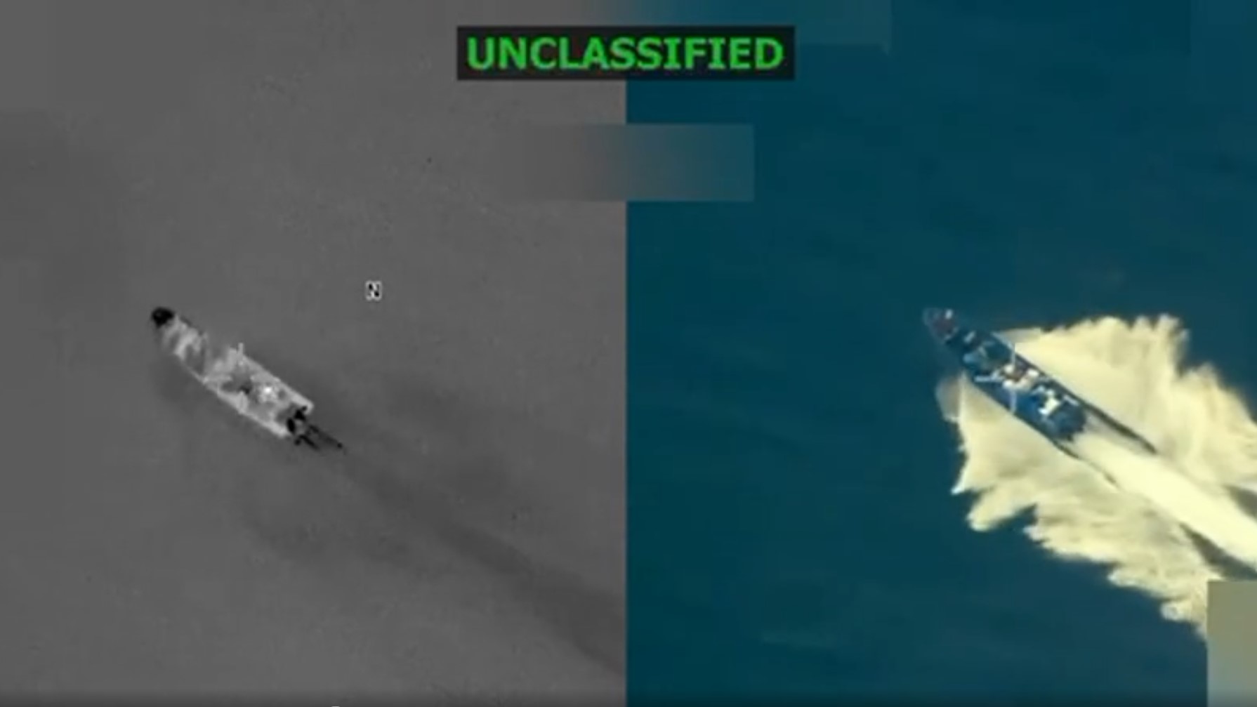 Screenshot of aerial footage showing a small boat moving through the sea.