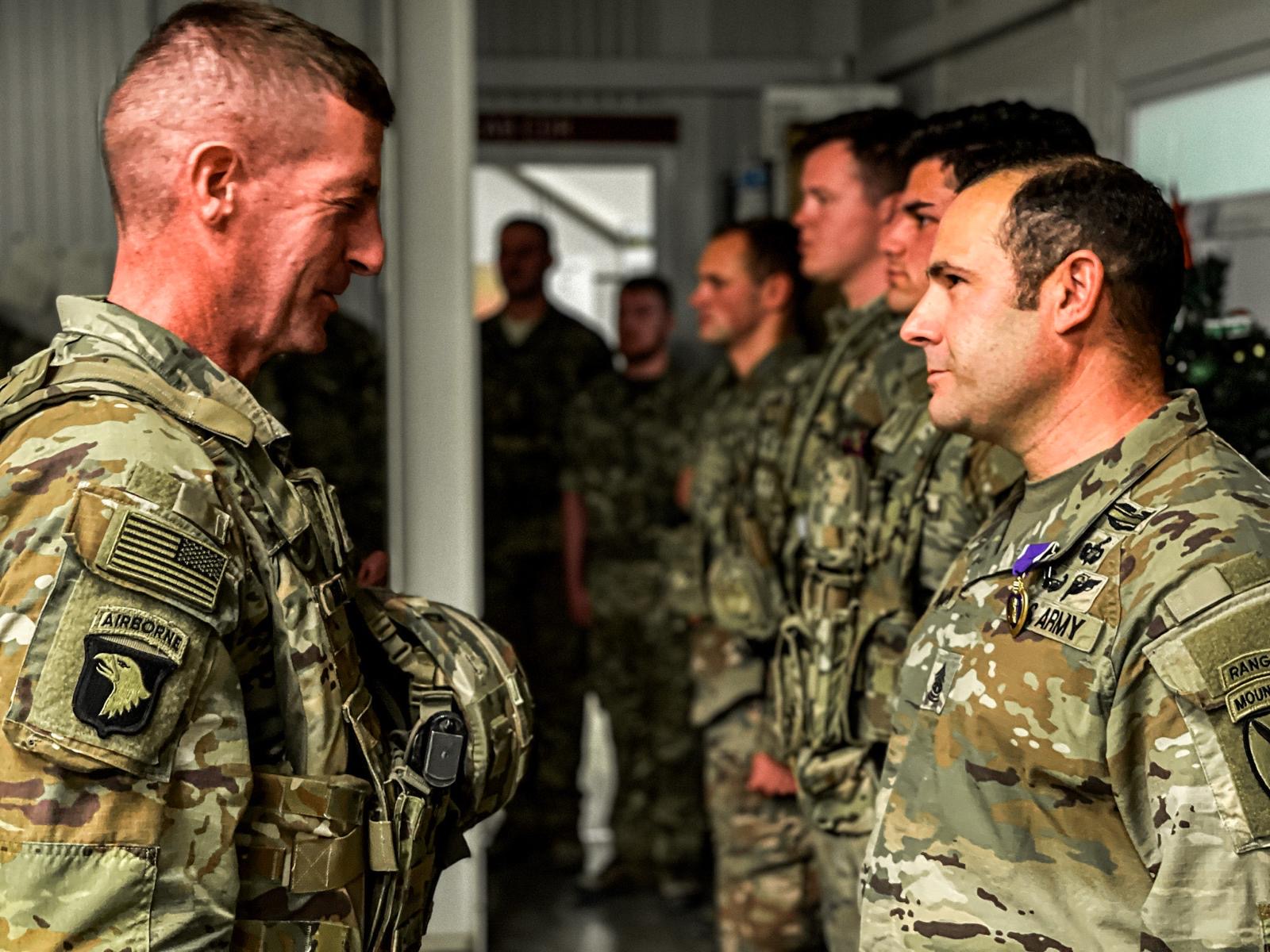 Command Sgt. Maj. Christopher Donaldson, right, receives a Purple Heart from Lt. Gen. Joel Vowell, the commander of Operation Inherent Resolve, for injuries he suffered in a drone attack during a deployment with the 2nd Brigade Combat Team in 2023 and 2024.