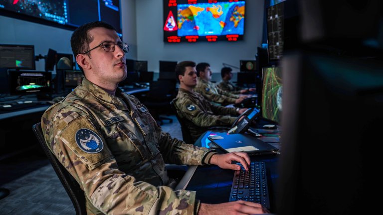 U.S. Space Force Guardians monitor workstations in the Combined Space Operations Center (CSpOC) at Vandenberg Space Force Base, Calif. The center operates 24 hours a day, seven days a week; continuously coordinating, planning, integrating, synchronizing and executing space operations; providing tailored space effects on demand to support combatant commanders; and accomplishing national security objectives. (Composited images are used over the monitors for operational security.)