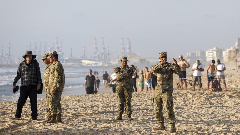 A US soldier gives the thumbs-up as an Israeli digger attempts to extricate a US military vessel (not pictured) that ran aground at a beach in the Israeli coastal city of Ashdod on May 25, 2024. The US military said four of its vessels, supporting a temporary pier built to deliver aid to Gaza by sea, had run aground in heavy seas. (Photo by Oren Ziv / AFP) (Photo by OREN ZIV/AFP via Getty Images)