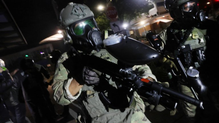 PORTLAND, OREGON - OCTOBER 04: Federal agents, including members of the Department of Homeland Security, the Border Patrol, and police, attempt to keep protesters back outside a downtown U.S. Immigration and Customs Enforcement (ICE) facility on October 04, 2025 in Portland, Oregon. The facility has become a focal point of nightly protests against the Trump administration. A federal judge in Portland has temporarily blocked President Trump from sending in the National Guard to quell protests. (Photo by Spencer Platt/Getty Images)