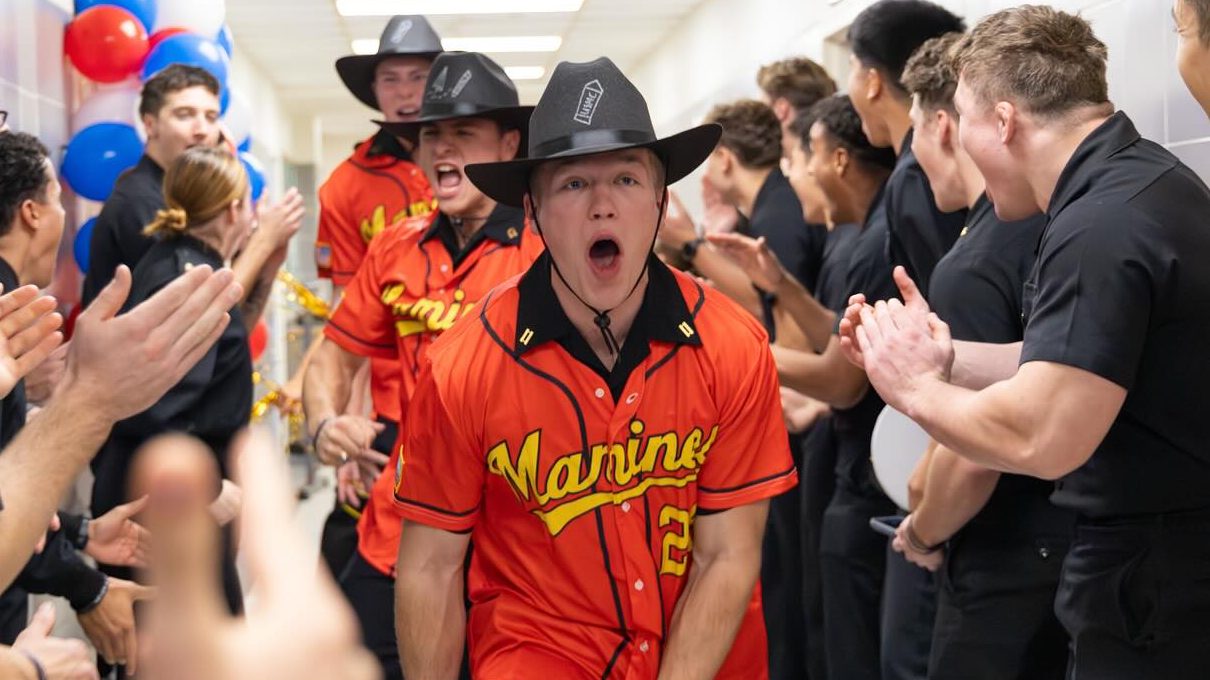 Three U.S. Naval Academy seniors celebrate their selection as future Marine Corps officers. Senior midshipmen learned on Nov. 20 what job they'll be in after graduation by receiving a customized 'team jersey' for that field.