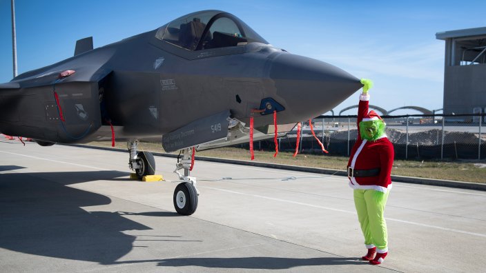The Grinch poses with a Tyndall F-35A Lightning II during Operation Jolly Jingle, a children’s holiday event hosted at Tyndall Air Force Base, Florida, Dec. 14, 2024. The event featured activities for the children such as face painting, a bounce house and photo opportunities with the Grinch and Santa Claus. (U.S. Air Force photo by Jennifer Jensen)