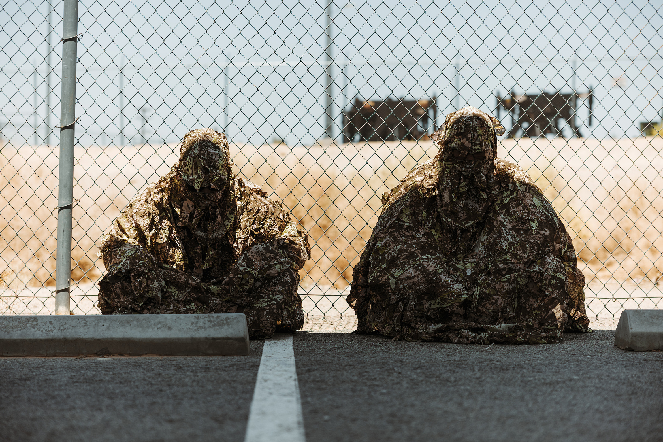 U.S. Marine Corps Cpl. Robert Bartlett, left, a California native, and Cpl. Ian Turner, a Louisiana native, both riflemen with Tactical Training and Exercise Control Group, Marine Air Ground Task Force Training Command, Marine Corps Air Ground Combat Center wear camouflage gear designed to enhance realism and effectiveness during Service Level Training Exercise 4-25 at MCAGCC, Twentynine Palms, California, July 21, 2025. SLTE provides integrated training across the Marine Air Ground Task Force to improve combat readiness and lethality. (U.S. Marine Corps photo by Lance Cpl. Micah Thompson)