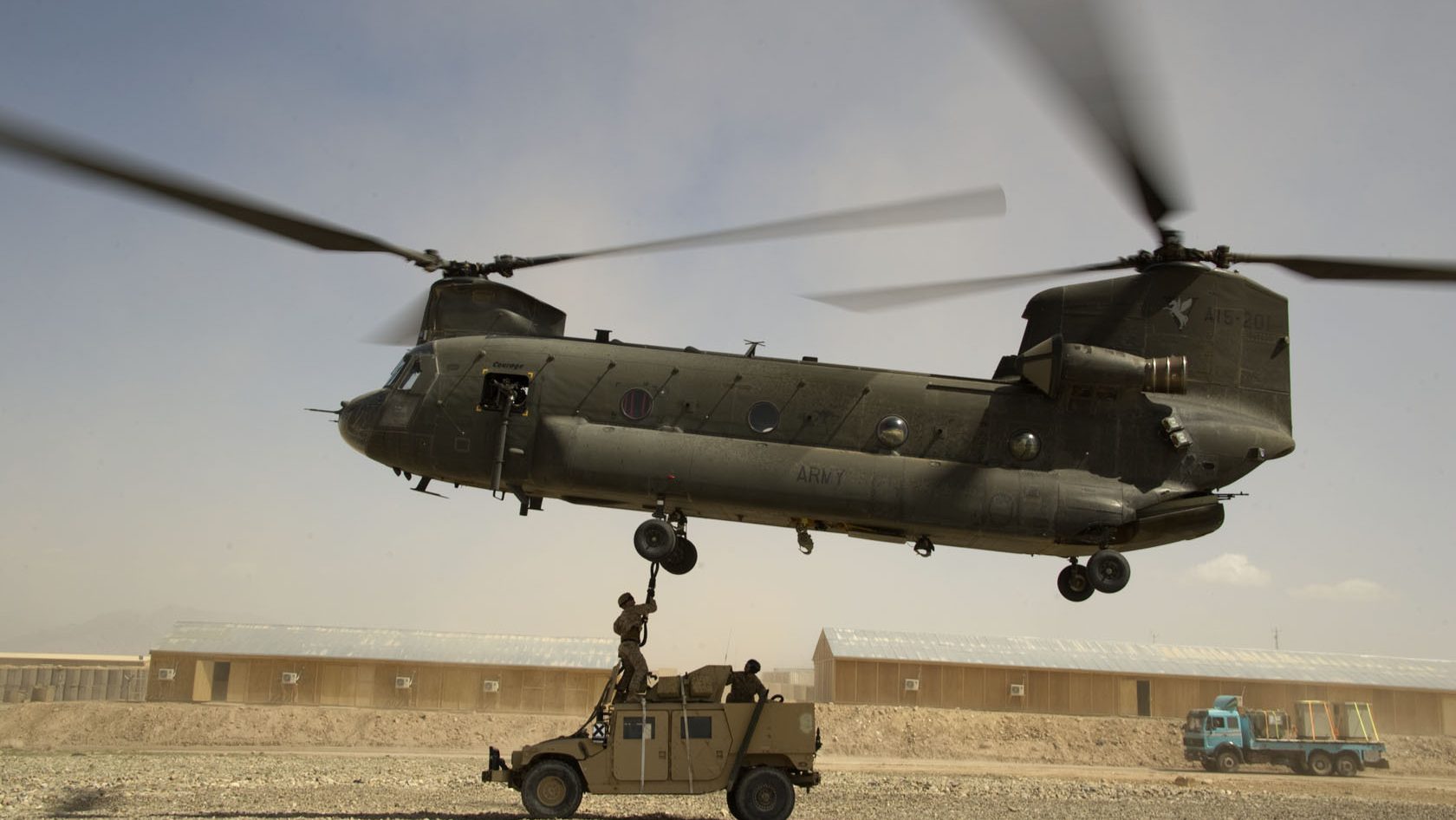 Special Operations Task Force South East aircrew team members hook a humvee up to a MH-47 Chinook helicopter during a sling-load operation in Tarin Kowt district, Uruzgan province, Afghanistan, March 26. Sling-loading is a method used to transport bulky equipment to coalition Special Operations Forces operating in austere locations around Afghanistan.