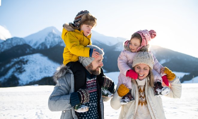 Front view of mother and father with son and daughter standing.