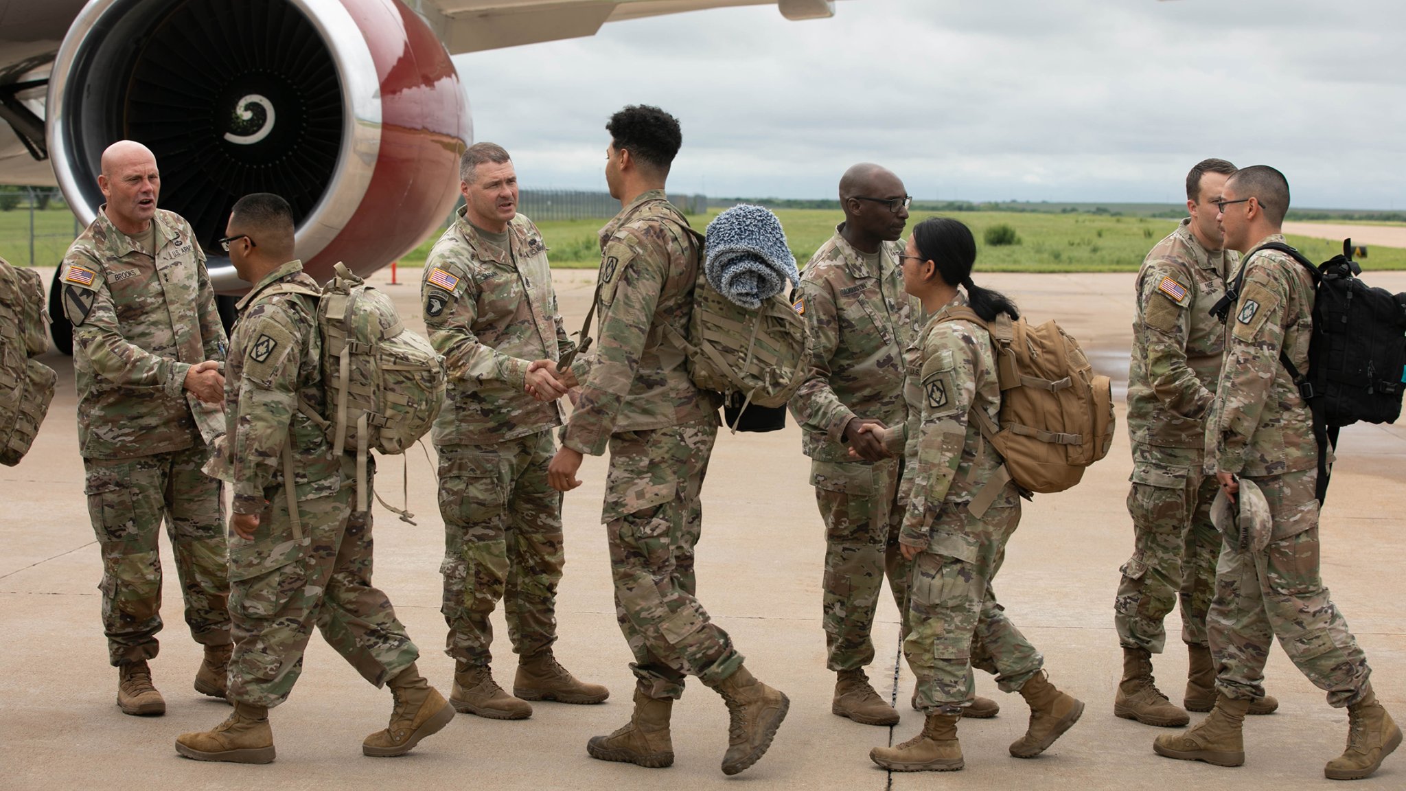 From left, Maj. Gen. Winston Brooks, Command Sgt. Maj. Neil Sartain, Command Sgt. Maj. Michael Augustin, and Maj. Benjamin Page shake the hands of soldiers assigned to the 1st Battalion, 14th Field Artillery regiment as they board a plane at the Lawton Fort Sill Regional Airport on May 2, 2024.