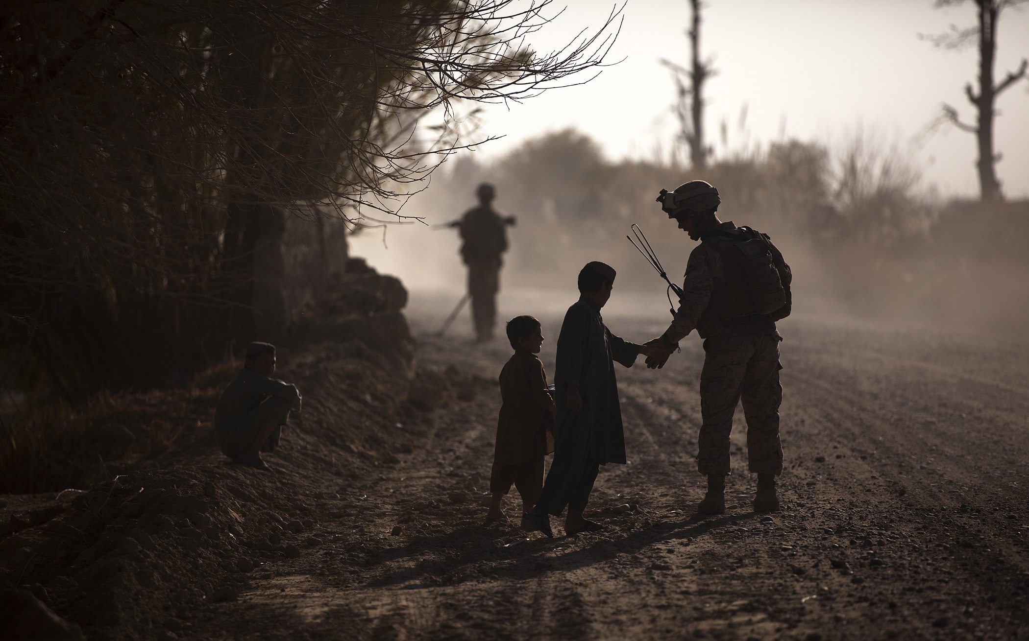U.S. Marine Corps Sgt. Jeremy Holsten (right), a squad leader with 3rd Platoon, Lima Company, 3rd Battalion, 3rd Marine Regiment, interacts with local children during a partnered security patrol with Afghan National Army soldiers in Kuchiney Darvishan, Afghanistan, on Dec. 18, 2011. The Marines aided the Afghan National Security Forces in assuming security responsibilities. (DoD photo by Cpl. Reece Lodder, U.S. Marine Corps. (Released))