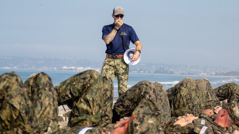 CORONADO, Calif. (Aug. 12, 2024) A Special Warfare Combat Crewman (SWCC) instructor motivates SWCC candidates before the conditioning run evolution of Alpha Phase at Naval Amphibious Base Coronado. Naval Special Warfare is the nation's elite maritime special operations force, uniquely positioned to extend the Fleet's reach and gain and maintain access for the Joint Force in competition and conflict. (U.S. Navy photo by Mass Communication Specialist 2nd Class Alex Kerska)