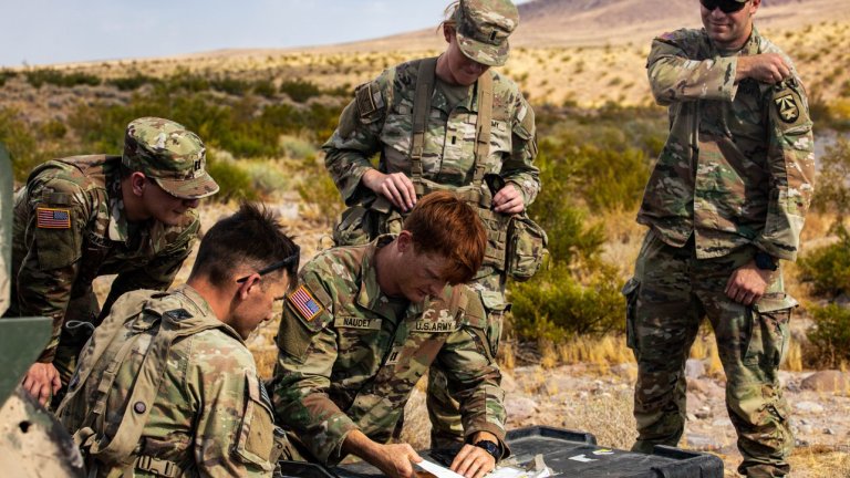 Image:  Soldiers assigned to 5th Squadron, 7th Cavalry Regiment, 1st Armored Brigade Combat Team, 3rd Infantry Division (3rd ID), Marne Innovation Center, 3rd ID and Artificial Intelligence Integration Center, Army Futures Command, discuss a Tethered Unmanned Aircraft System with Sentinel Software at the National Training Center, Fort Irwin, California, July 18, 2024. By combining forces, the U.S. Army utilizes assets and creates technology to increase the lethality of its brigades, while also cultivating a culture of innovation. (U.S. Army photo by Spc. Rebeca Soria)