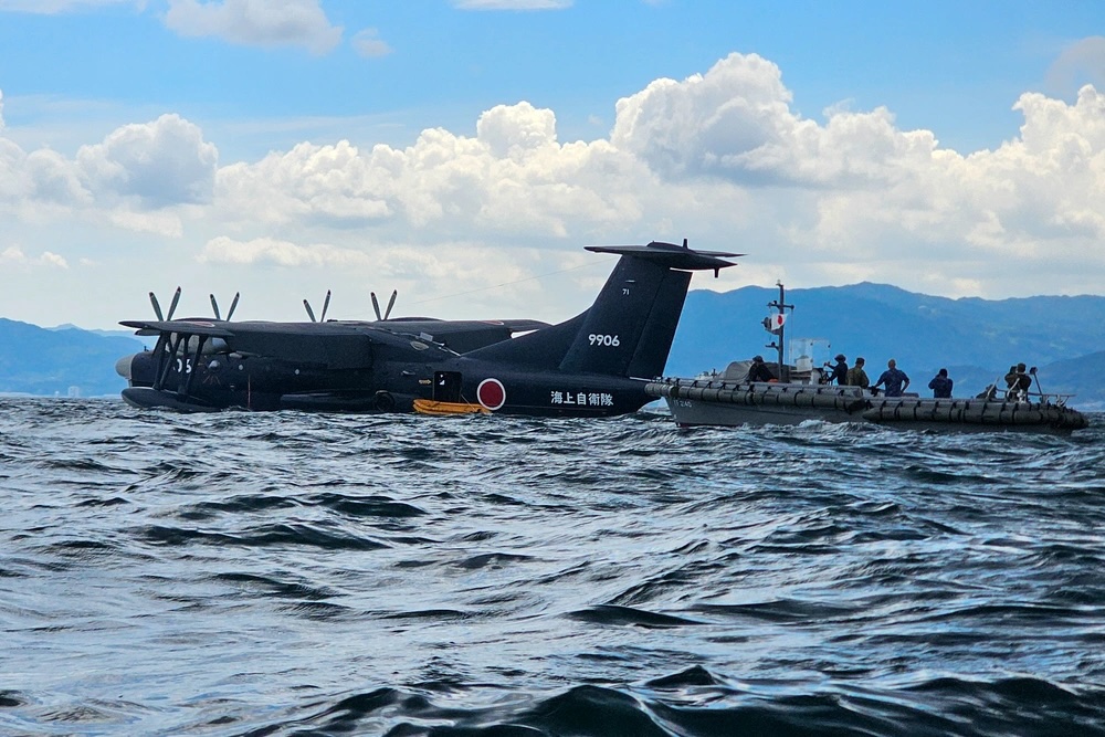 Japan Maritime Self-Defense Force members make their way to a US-2 aircraft, both with Air Rescue Squadron 71, Fleet Air Wing 31, off the coast of Marine Corps Air Station Iwakuni, Japan, Sept. 9, 2025.