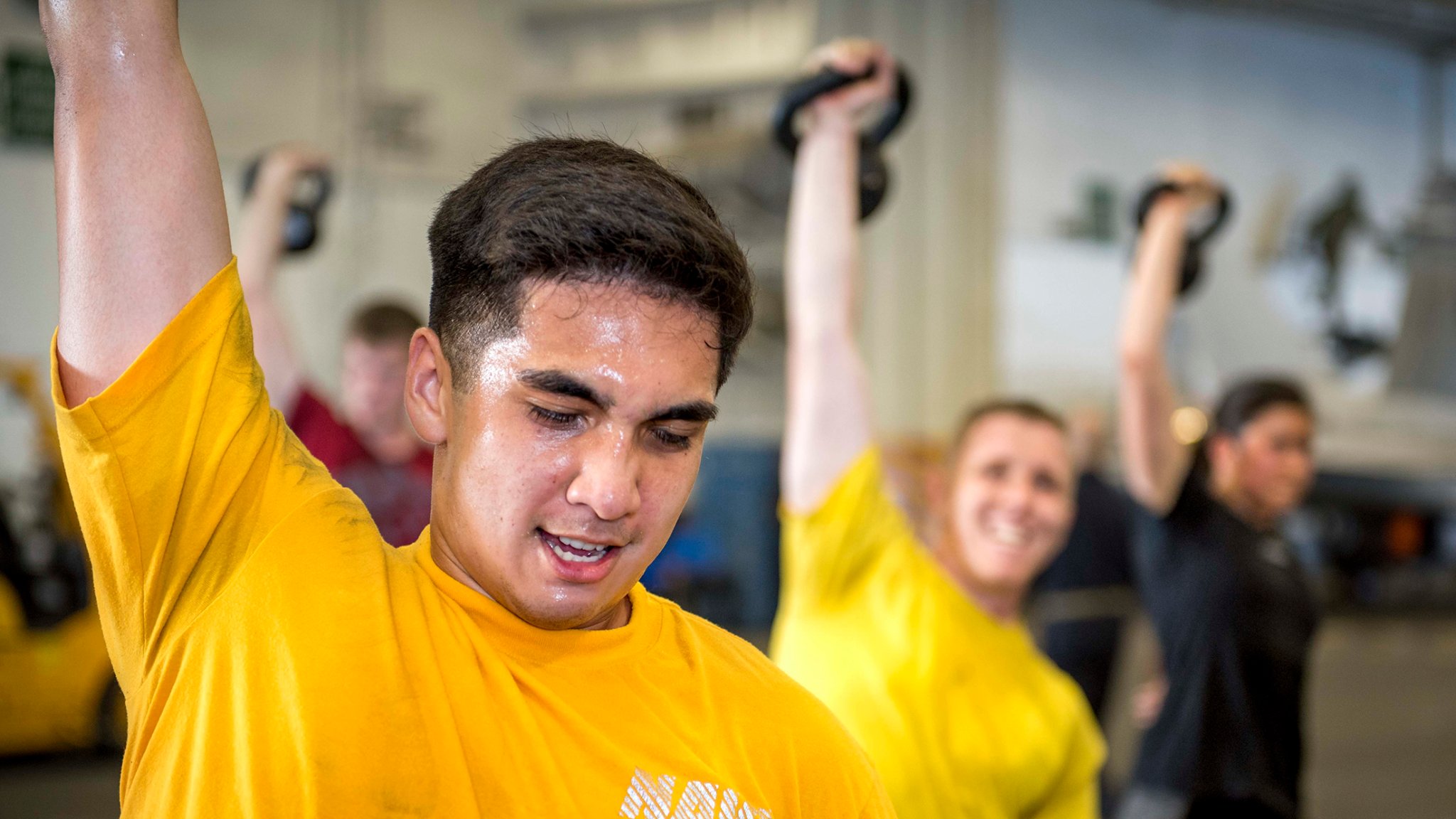 180606-N-SO730-0181 ATLANTIC OCEAN (June 6, 2018) Midshipman Gabriel Perez performs kettle bell exercises during a group workout aboard the aircraft carrier USS George H.W. Bush (CVN 77). The ship is underway conducting routine training exercises to maintain carrier readiness. (U.S. Navy photo by Mass Communication Specialist 3rd Class Joe Boggio)