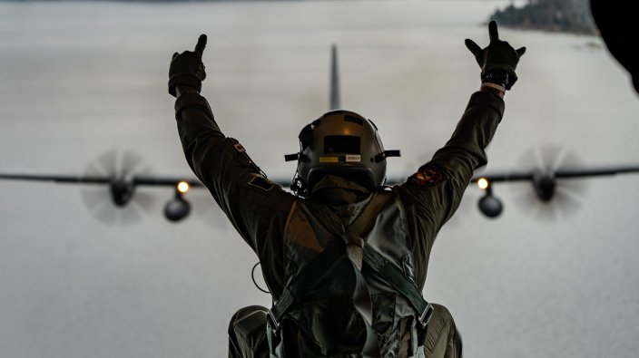 A Nevada Air National Guard C-130H flies above Lake Tahoe during a "spouse lift" while Master Sgt. Billy Johnson, loadmaster with the 192nd Airlift Squadron, sits on the ramp, October 30, 2024. The 152nd Airlift Wing, Nevada Air National Guard, held the spouse lift to explain the mission of the Nevada Air National Guard and to recognize spouses for supporting their military members (Air National Guard photo by Staff Sgt. Michelle Brooks).