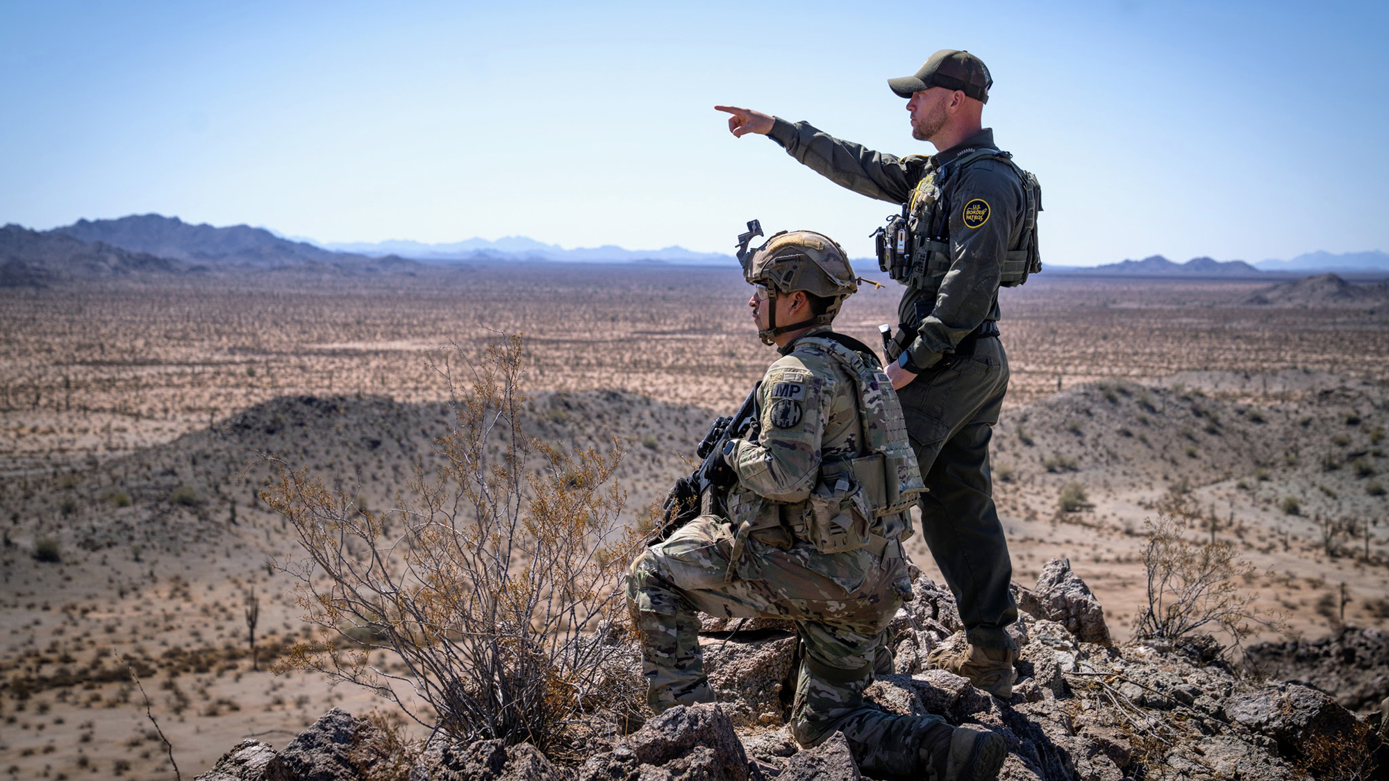 U.S. Army Spc. Israel Arreguin with the Headquarters and Headquarters Detachment, 759th Military Police Battalion, assigned to Joint Task Force - Southern Border and a Border Patrol agent conduct detection and monitoring operations from an observation post near Wellton, Ariz., April 23, 2025. Under the direction of U.S. Northern Command, Joint Task Force – Southern Border aligns efforts to seal the southern border and repel illegal activity and is responsible for full-scale, agile, and all-domain operations, which will allow for more effective and efficient DoD operations. (U.S. Army photo by 2nd Lt. Erica Esterly)