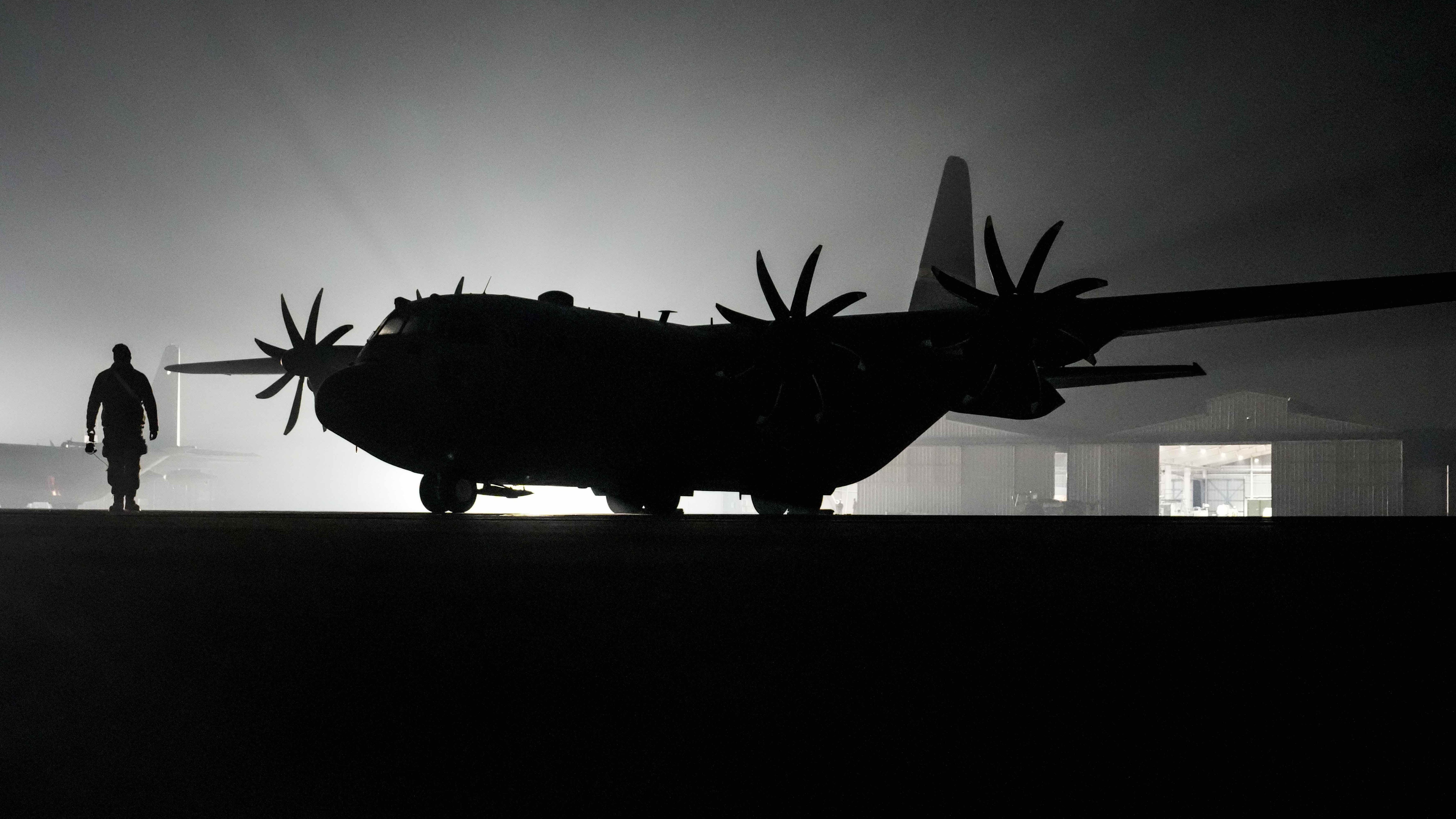 An Air Commando passes by a C-130 Hercules assigned to the 152nd Airlift Wing during exercise Southern Star '25 in Santiago, Chile, May 29, 2025. Southern Star ’25 is a multinational special operations exercise taking place across Chile from May 26 to June 8. The exercise brings together forces from six nations and 10 observer countries, totaling more than 2,700 participants, to enhance interoperability and strengthen global special operations partnerships through joint training from Antofagasta to Punta Arenas. (U.S. Air Force photo by Airman 1st Class Gracelyn Hess)