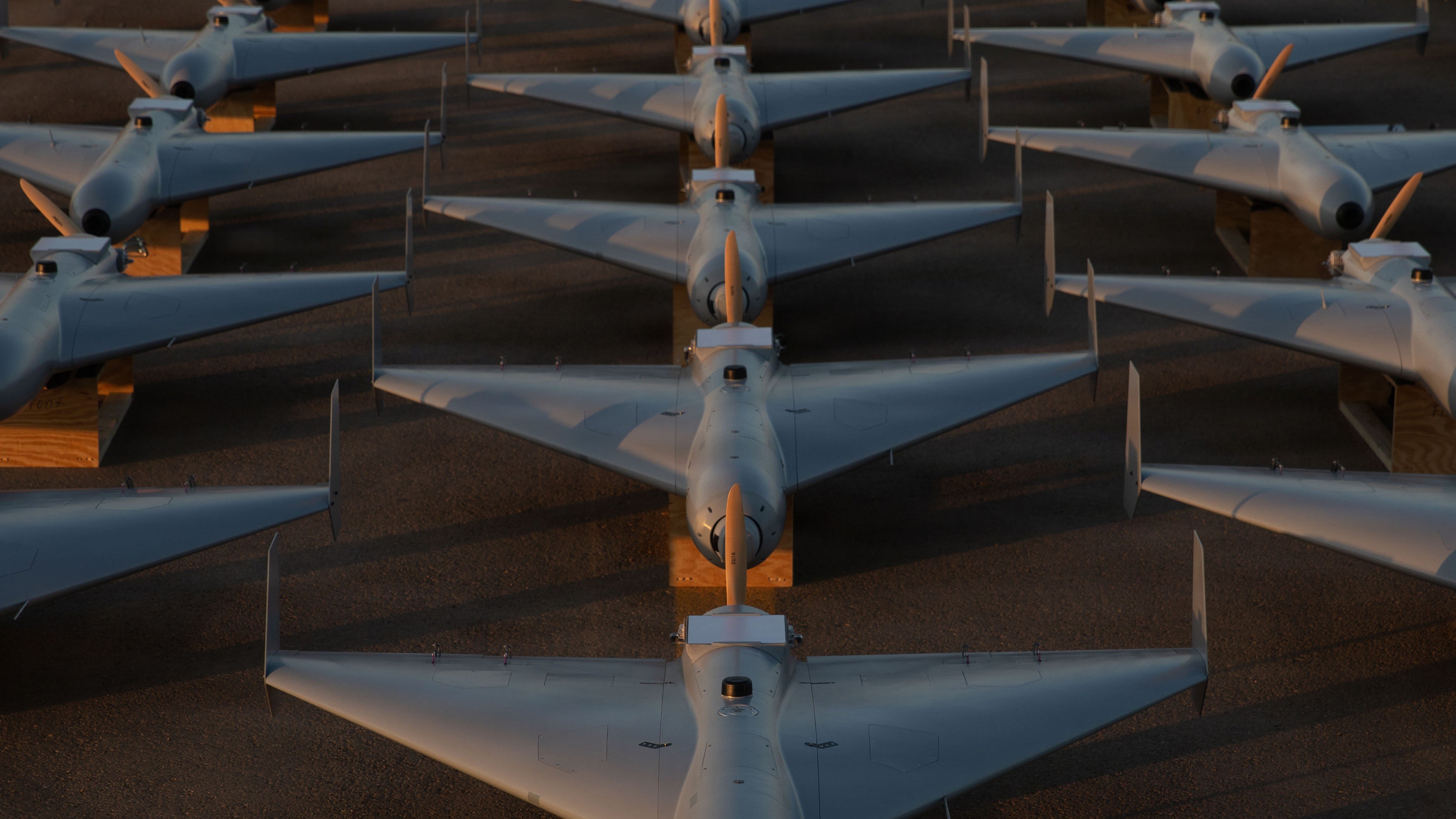 Image: U.S. CENTRAL COMMAND AREA OF RESPONSIBILITY (Nov. 23, 2025) Low-cost Unmanned Combat Attack System (LUCAS) drones are positioned on the tarmac at a base in the U.S. Central Command (CENTCOM) operating area, Nov. 23. The LUCAS platforms are part of a one-way attack drone squadron CENTCOM recently deployed to the Middle East to strengthen regional security and deterrence. (Courtesy Photo)