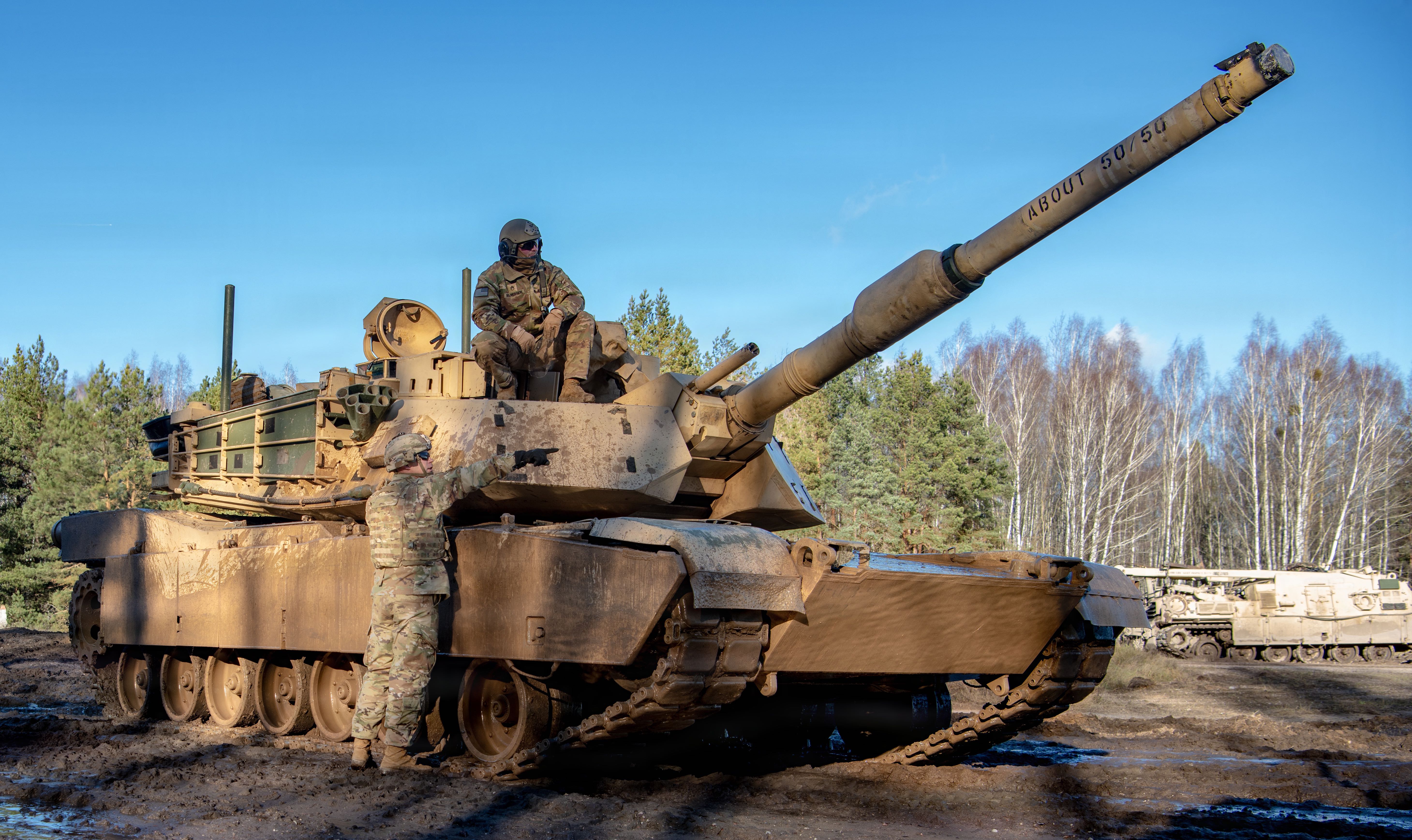 U.S. Army Soldiers assigned to 3rd Battalion, 66th Armored Regiment, 1st Armored Brigade Combat Team, 1st Infantry Division received ground level information from scout elements after convoying from a designated start point during the Forward Land Forces Expansion exercise at Bemowo Piskie, Poland, Nov. 18, 2025. The scouts passed terrain and movement observations to the tank crews, enabling them to adjust their plan before maneuvering toward their next position. The task force provides combat-credible forces to V Corps, America’s only forward-deployed corps in Europe. (U.S. Army photo by Sgt. Eric Allen)