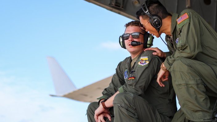 From left, U.S. Air Force Tech. Sgt. Levi Grant and Senior Airman Ivan Chen, 137th Airlift Squadron flying crew chiefs, 105th Airlift Wing, Stewart Air National Guard Base, Newburgh, New York, sit and kneel on the ramp of a C-17 Globemaster III, assigned to the 105th AW, while preparing to transport 177th Medical Group (MDG) airmen, 177th Fighter Wing, New Jersey Air National Guard, at the 177FW, Egg Harbor Township, New Jersey, Sept. 13, 2024. More than 30 airmen with the 177th MDG will attend clinical rotations at Naval Medical Center San Diego, San Diego, California, as part of Medical Facility Annual Training, Operation Pacific Surge. (U.S. Air National Guard photo by Airman 1st Class Connor Taggart)