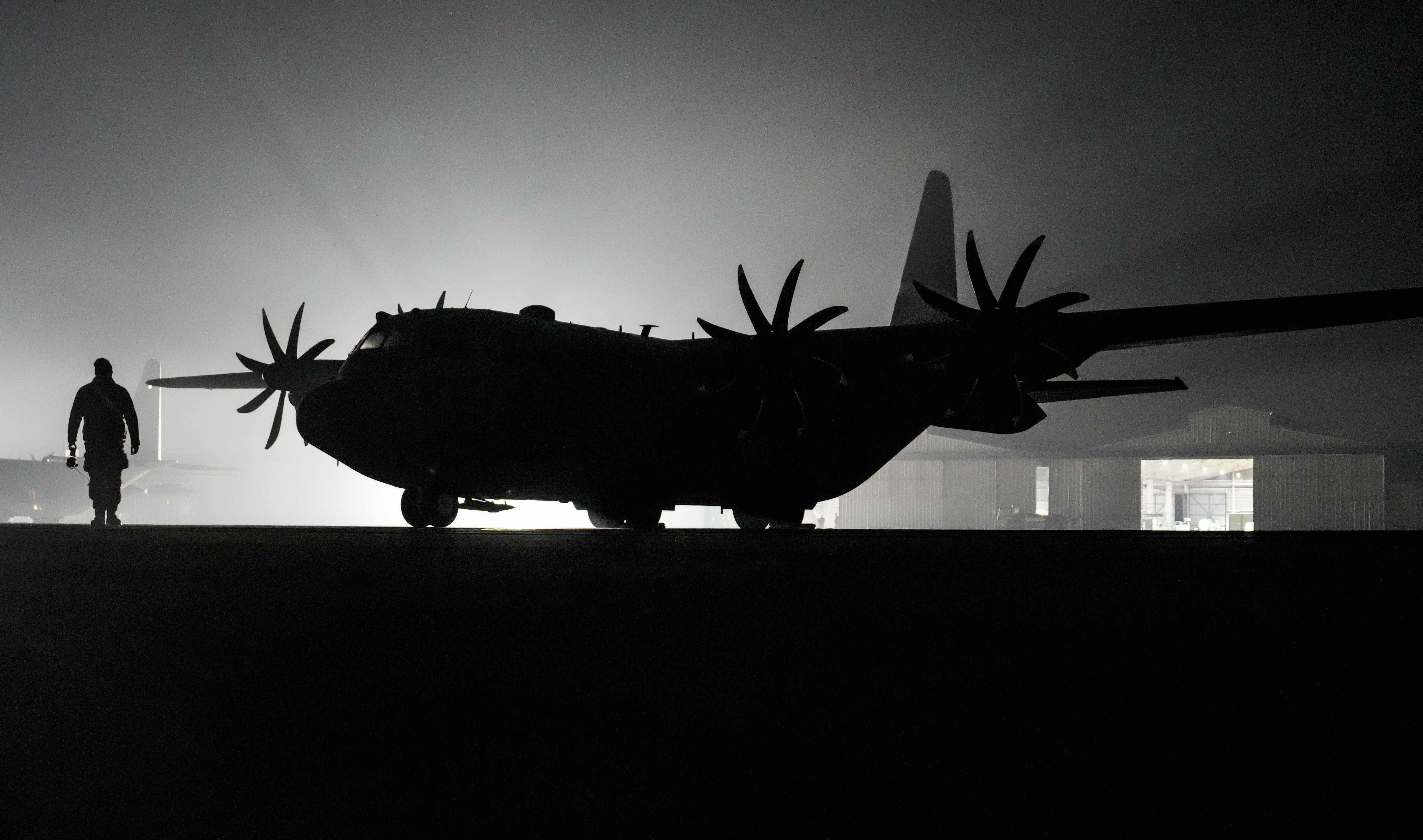 An Air Commando passes by a C-130 Hercules assigned to the 152nd Airlift Wing during exercise Southern Star '25 in Santiago, Chile, May 29, 2025. Southern Star ’25 is a multinational special operations exercise taking place across Chile from May 26 to June 8. The exercise brings together forces from six nations and 10 observer countries, totaling more than 2,700 participants, to enhance interoperability and strengthen global special operations partnerships through joint training from Antofagasta to Punta Arenas. (U.S. Air Force photo by Airman 1st Class Gracelyn Hess)