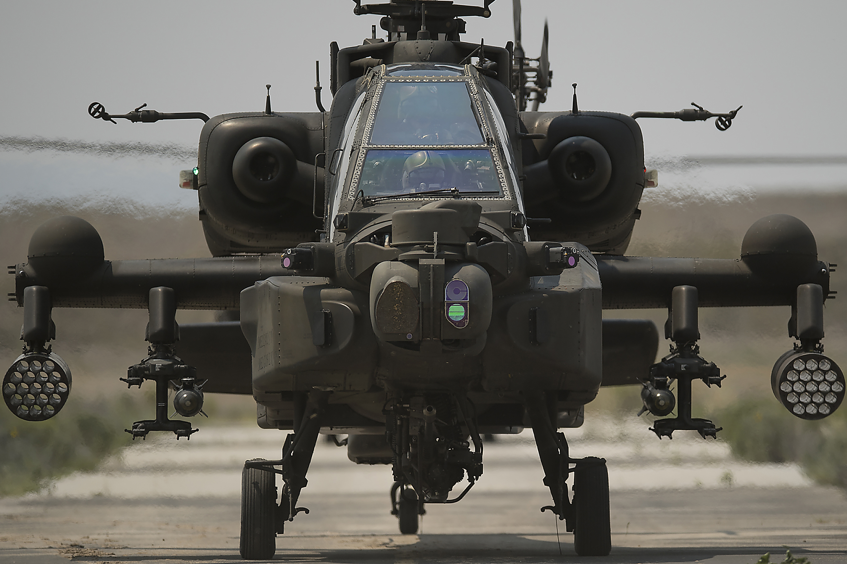The second AH-64 Apache rolls onto the taxiway and to the takeoff pad. The Idaho Army National Guard's Orchard Combat Training Center was host to elements of the Republic of Singapore Air Force during July. Based in Arizona, The Singapore contingent operates eight AH-64 Apache Helicopters as part of the Peace Vanguard Task Force. The Apache is an attack helicopter with a tandem cockpit for a crew of two. It features a nose-mounted sensor for target acquisition and night vision systems. It is armed with a 30 mm M230 chain gun. It also features four hardpoints mounted on stub-wing pylons for carrying armament, typically a mixture of AGM-114 Hellfire missiles and Hydra 70 rocket pods. The Apache’s first flight took place in 1975 and was formally introduced into the U.S. Army in 1986.