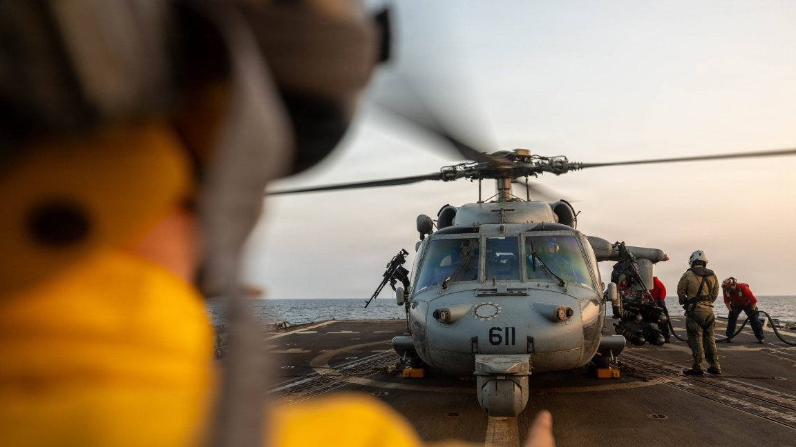 A U.S. Navy Boatswain’s Mate signals to an MH-60S Sea Hawk helicopter, attached to Helicopter Sea Combat Squadron (HSC) 14, on the flight deck of Arleigh Burke-class guided-missile destroyer USS Spruance (DDG 111) during Operation Epic Fury, Mar. 5, 2026. (U.S. Navy photo)