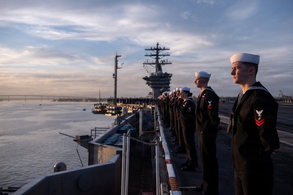 U.S. Sailors man the rails on the flight deck of Nimitz-class aircraft carrier USS Nimitz (CVN 68) during the ship's departure from Naval Air Station North Island, San Diego, March 14, 2026. Nimitz is underway in the U.S. 3rd Fleet area of operations as part of a scheduled homeport shift to Norfolk, Virginia. (U.S. Navy photo by Mass Communication Specialist 2nd Class Peter K. McHaddad)