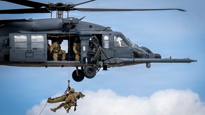 An HH-60W Jolly Green II hoists a simulated survivor during an aerial demonstration for Saluting Our Aviation Roots, Feb. 25, 2026, at Moody Air Force Base, Ga. The demonstration highlighted combat search and rescue capabilities for students and families. (U.S. Air Force photo by Airman Bre Lewis)