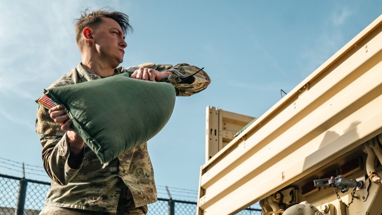 Sgt. Nathan Winter lifts a 40-lbs sandbag as part of the Army's new Combat Field Test at Joint Base Myer-Henderson Hall, Virginia.