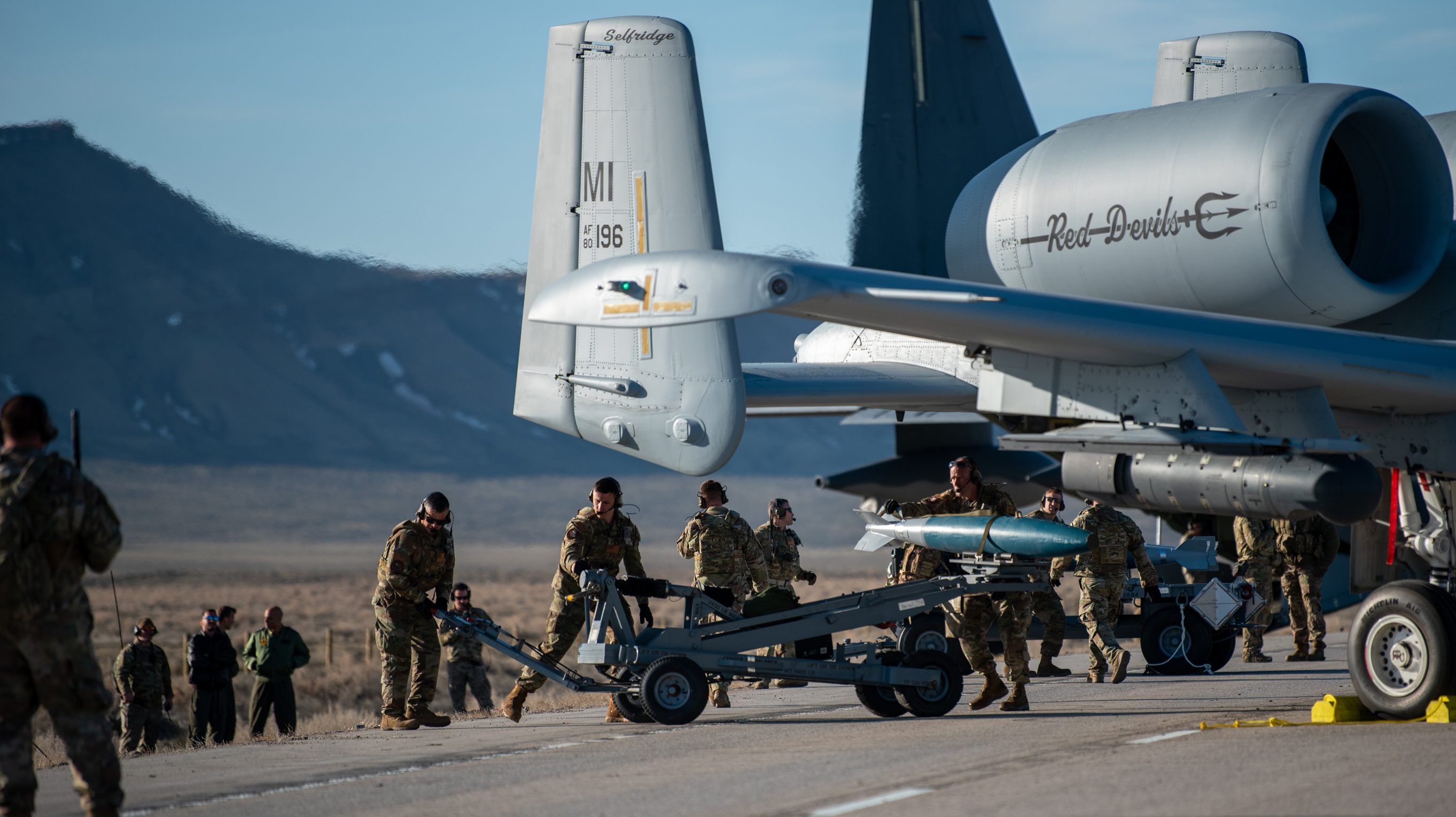 Airmen with the 127th Fighter Wing conduct an Integrated Combat Turn weapons reload on one of their A-10 Thunderbolt IIs on Highway 287 during Exercise Agile Chariot, April 30, 2023, honing capabilities linked to Agile Combat Employment. Instead of relying on large, fixed bases and infrastructure, ACE employs smaller, more dispersed locations and teams to rapidly move aircraft, pilots and other personnel as needed. Under ACE, millions of miles of public roads can serve as functional runways with Forward Arming and Refueling Points when necessary. (U.S. Air National Guard photo by Master Sgt. Phil Speck)