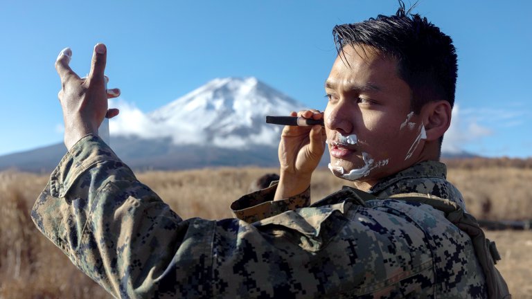U.S. Marine Corps Cpl. Nhien Do shaves during Artillery Relocation Training Program 23.3 in the North Fuji Maneuver Area at Combined Arms Training Center Camp Fuji, Japan, Nov. 26, 2023. Marines continue to maintain good hygiene and grooming standards while in field conditions. The skills developed at ARTP increase the proficiency and readiness of the only permanently forward-deployed artillery unit in the Marine Corps, enabling them to provide indirect fires. Do, a native of Milwaukee, Wisconsin, is an artilleryman with Alpha Battery, 3d Battalion, 12th Marine Littoral Regiment, 3d Marine Division. (U.S. Marine Corps photo by Sgt. Alyssa Chuluda)