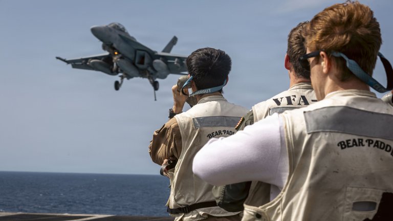 U.S. Sailors assigned to Carrier Air Wing 8 observe an F/A-18E Super Hornet aircraft, attached to Strike Fighter Squadron 31, land on the flight deck of the USS Gerald R. Ford (CVN 78), while underway during Operation Epic Fury, March 18, 2026. (U.S. Navy photo)