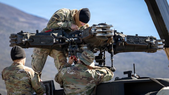 A maintenance crew comprised of AH-64 Attack Helicopter Repairers assigned to Delta Company, 2nd Squadron, 6th Cavalry Regiment "Sabers", 25th Combat Aviation Brigade, rebuild a rotor head after a static mass repair on a AH-64 Apache Helicopter at Pohakuloa Training Area, Hawaii from February 2-25, 2026. This repair took place during aerial gunnery. For AH-64 Apache crews, aerial gunnery is a semi-annual requirement necessary to maintain proficiency of aircrews, and allows the unit to build a more reliable combat power. (U.S. Army Photo by Sgt. Olivia Cowart)