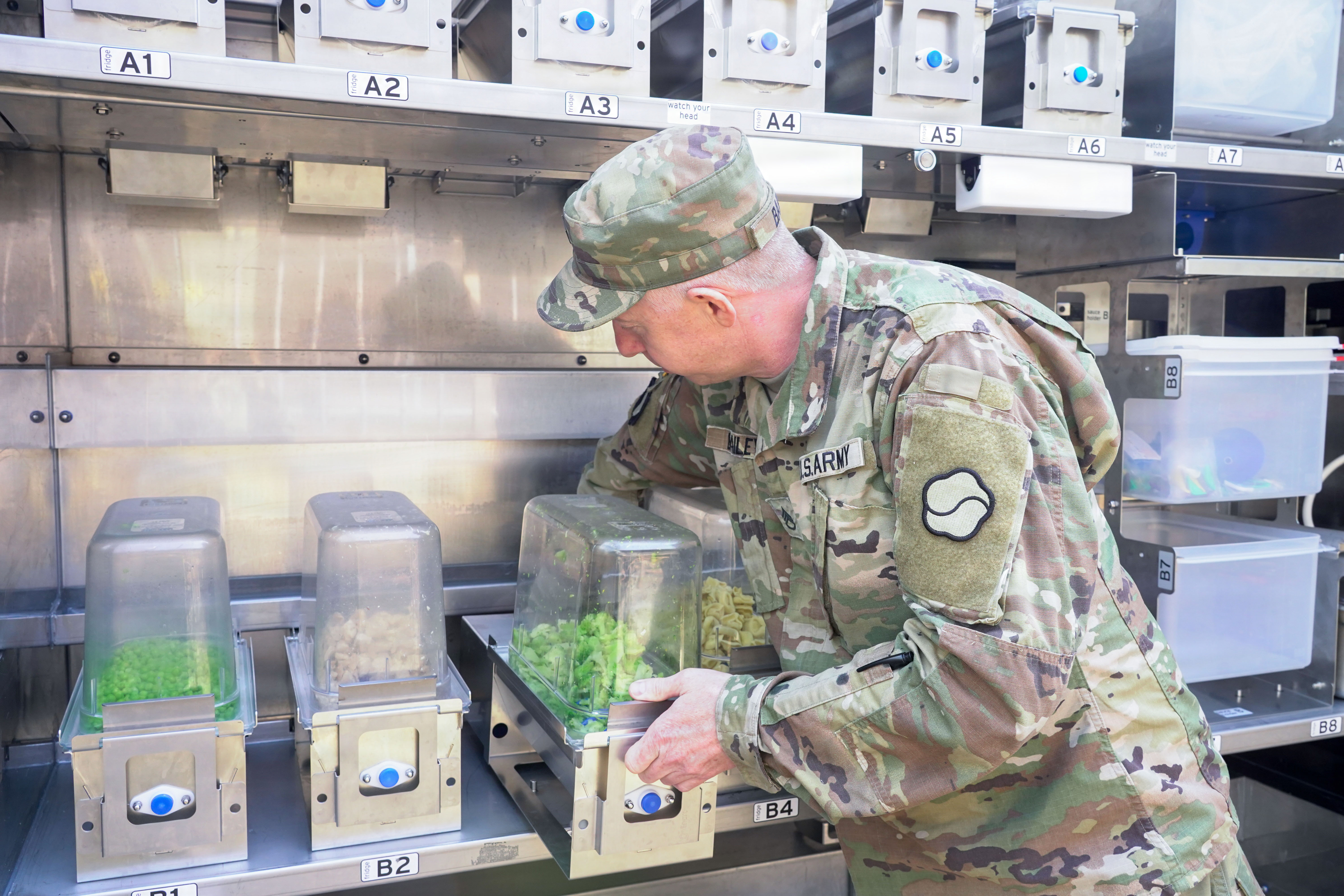 U.S. Army Staff Sgt. Darren Bailey, noncommissioned officer in charge of Market 19, 19th Expeditionary Sustainment Command, loads ingredients into the Sustained Autonomous Meals system at Camp Walker, Daegu, Republic of Korea, Mar. 26, 2026. The system allows a small team to support large formations by streamlining food preparation and increasing output through automation. (U.S. Army photo by Sgt. Deziree Keay)