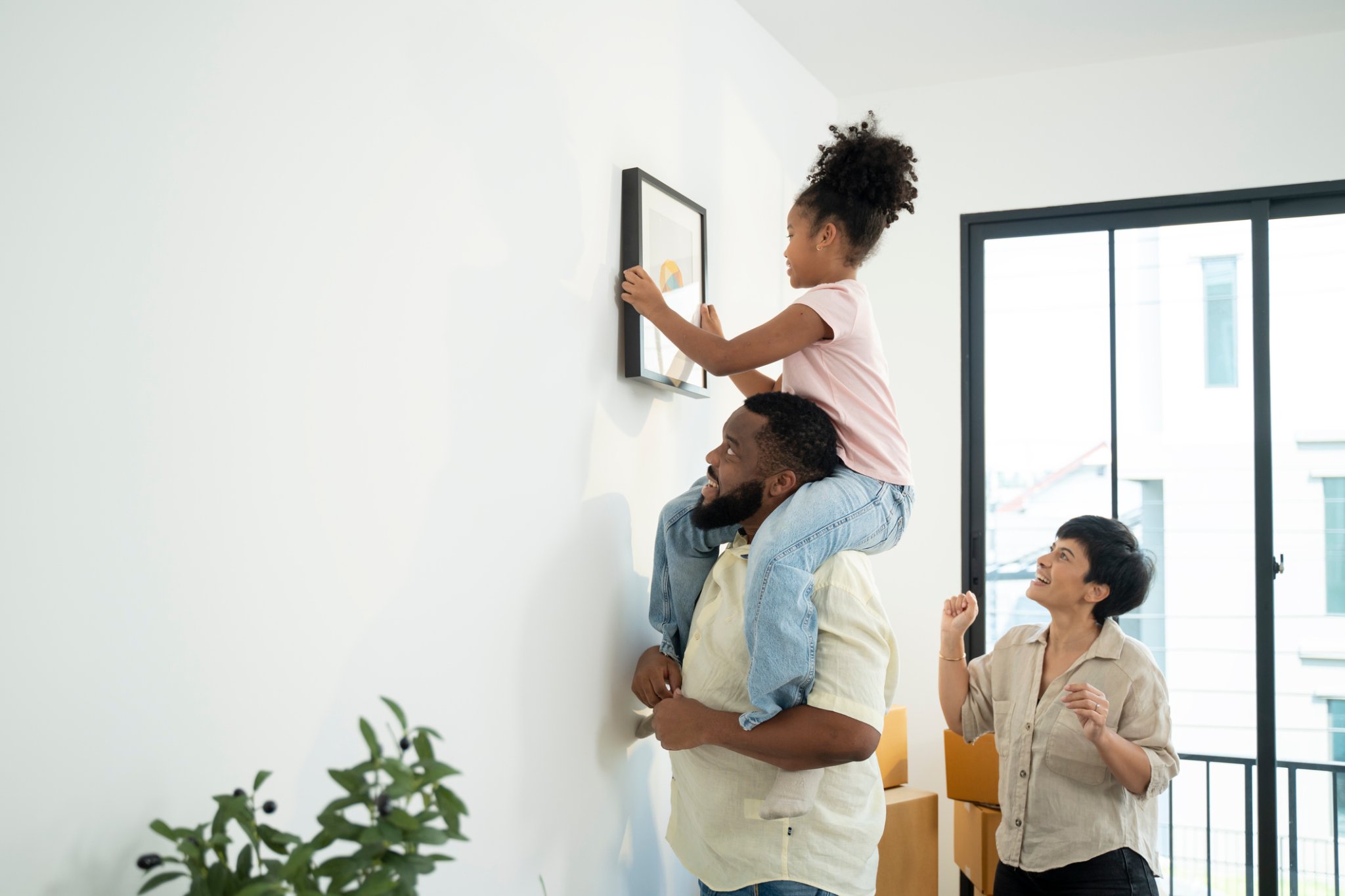Happy parents having fun while holding their small children. After moving to a new apartment