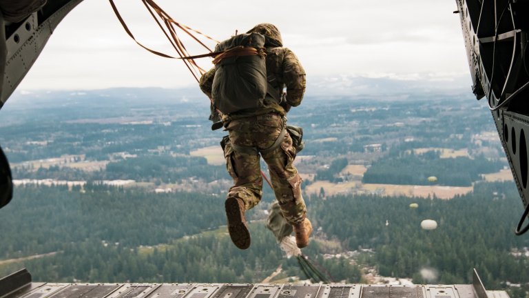 Washington National Guard Soldiers with 1st Battalion, 168th General Support Aviation Regiment (GSAB), 96th Aviation Troop Command, transport 1st Special Forces Group (Airborne) and Canadian partners over Rogers Drop Zone on Joint Base Lewis-McChord, Wash., Dec. 6, 2022. The joint static line jump was part of the 78th Annual Menton Week celebrations commemorating the anniversary of the combined U.S. and Canadian First Special Service Force deactivation. (U.S. Army National Guard photo by Staff Sgt. Adeline Witherspoon)