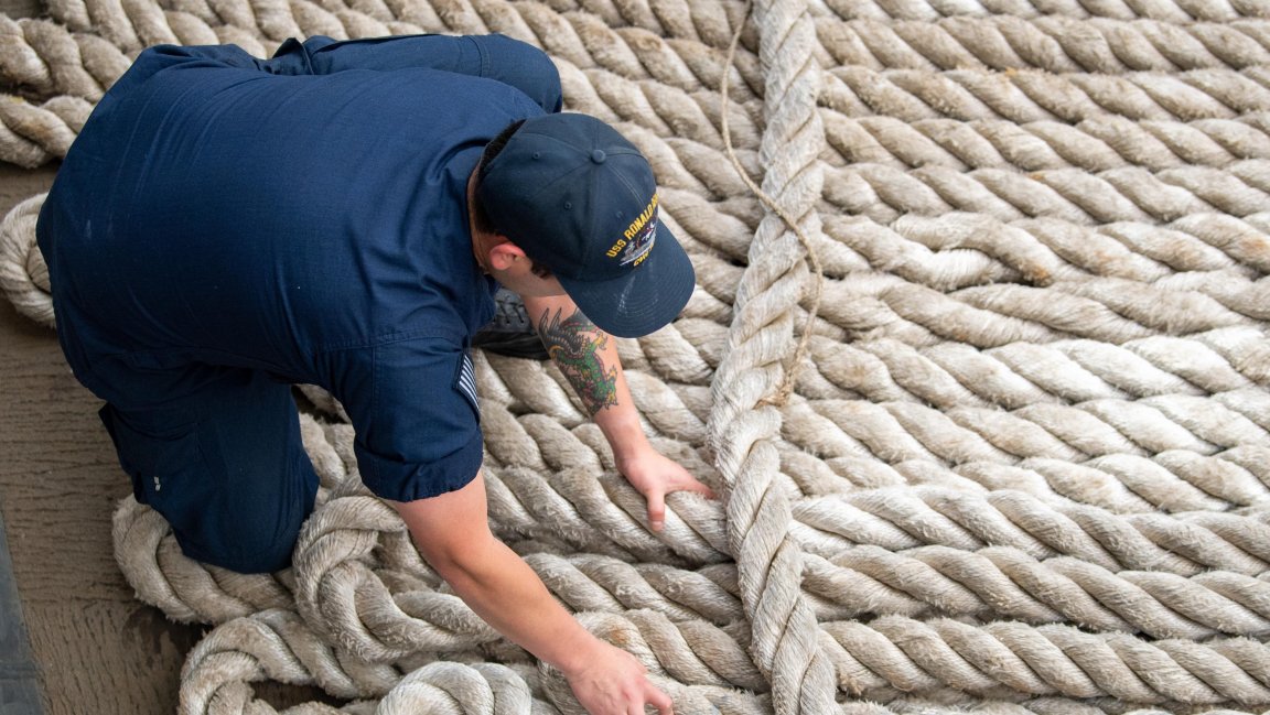 Air Traffic Controller 2nd Class Angel Villegas, from Los Angeles, fakes down a mooring line on the fantail onboard Nimitz-class aircraft carrier USS Ronald Reagan (CVN 76), prior to departing Naval Base Kitsap in Bremerton, Washington, Dec. 2, 2024. Ronald Reagan provides a combat-ready force that protects and defends the United States, and supports alliances, partnerships and collective maritime interests in the Indo-Pacific region. (U.S. Navy photo by Mass Communication Specialist Seaman Apprentice Dylan ONeal)