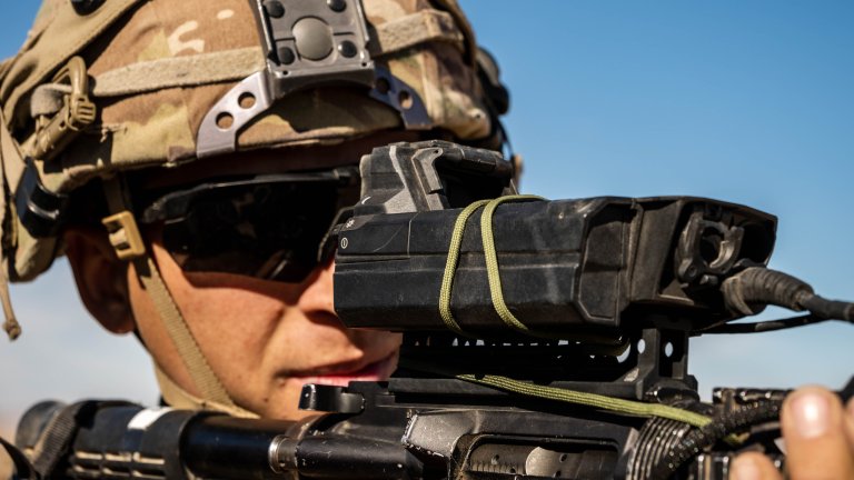 Spc. Brandon Mack, a small unmanned aircraft system operator assigned to 1st Battalion, 8th Cavalry Regiment, 2nd Armored Combat Brigade, 1st Cavalry Division, looks through his SMASH 2000L optic, a counter-sUAS tracking scope developed by SMARTSHOOTER, during rotation 26-02 at the National Training Center, Fort Irwin, California, Nov. 2, 2025. The rotation marks the first armored Transforming in Contact (TiC) 2.0 combat training center rotation, where new concepts and emerging capabilities were tested in realistic, contested scenarios. (U.S. Army photo by Spc. Julian A. Winston)