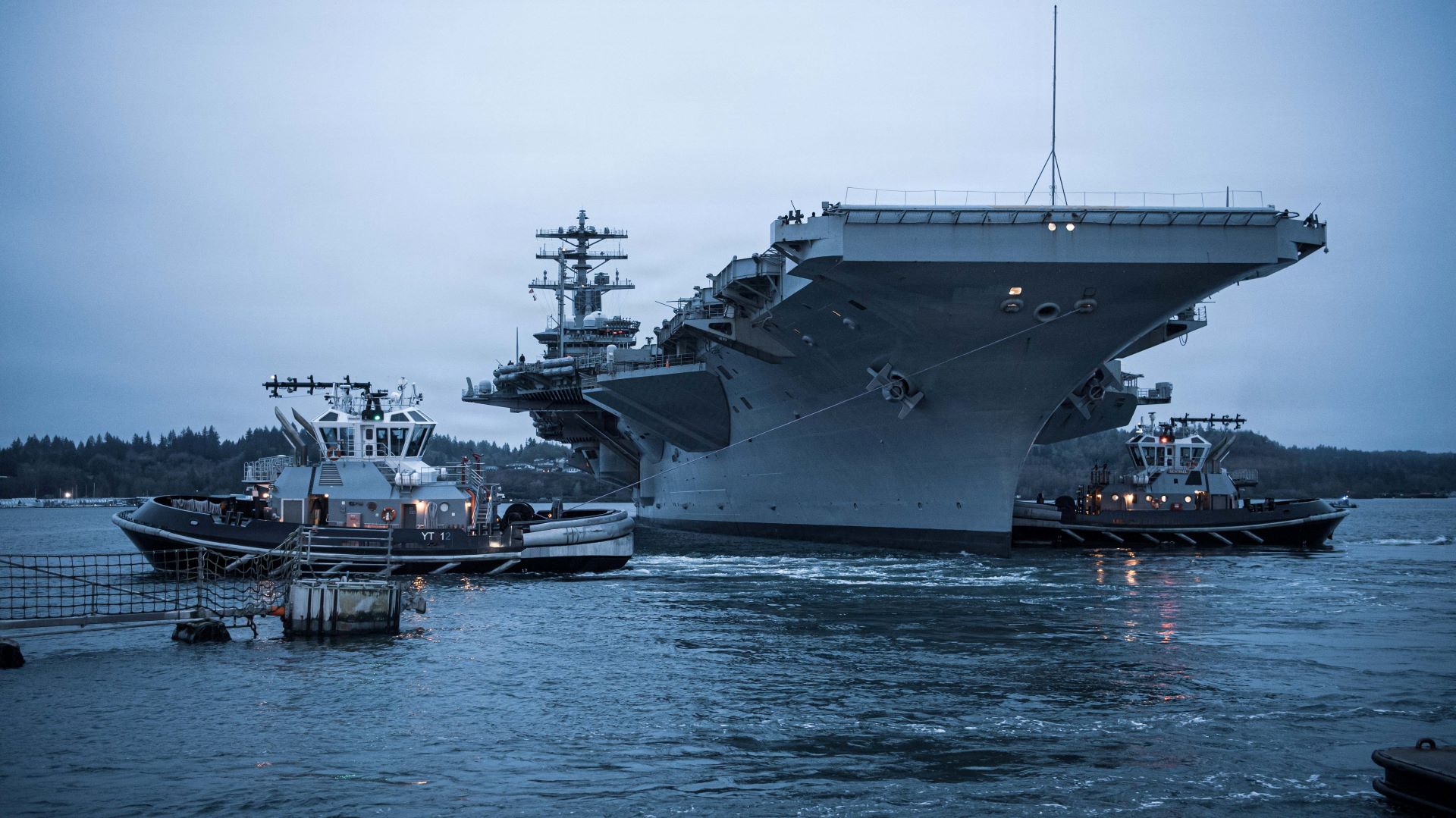The Nimitz class aircraft carrier USS Nimitz (CVN 68) pulls away from the pier with the help of tugs during the ship’s final departure from Naval Base Kitsap-Bremerton, Washington, March 7, 2026. Nimitz is underway in the U.S. 3rd Fleet area of operations as part of a scheduled homeport shift to Norfolk, Virginia. (U.S. Navy photo by Mass Communication Specialist 3rd Class Dylan O’Neal)  Naval Base Kitsap is home to several submarines and was the home port for the USS Nimitz, which departed for the last time in March.